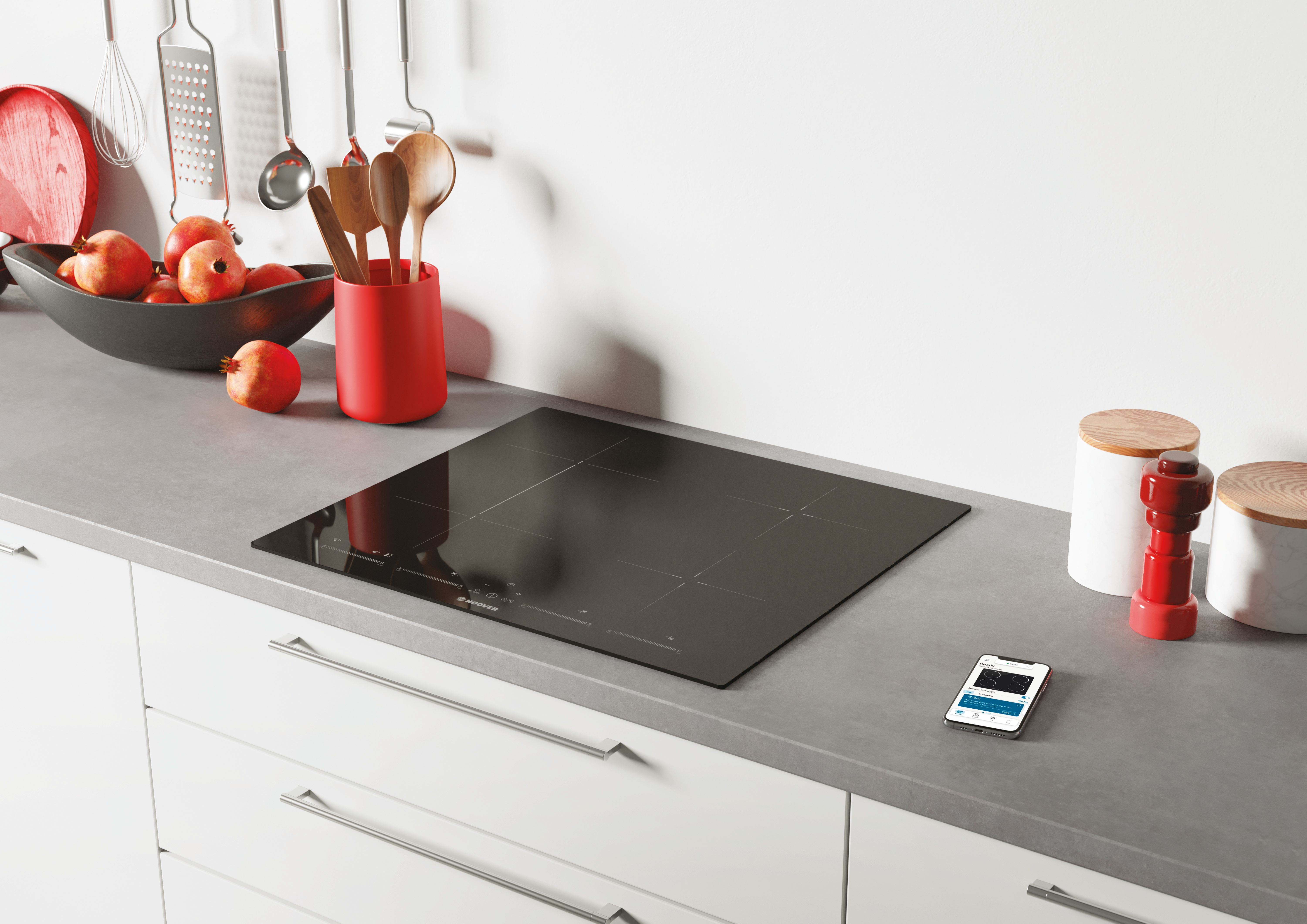 Czarna płyta indukcyjna na szarym blacie ze smartfonem.