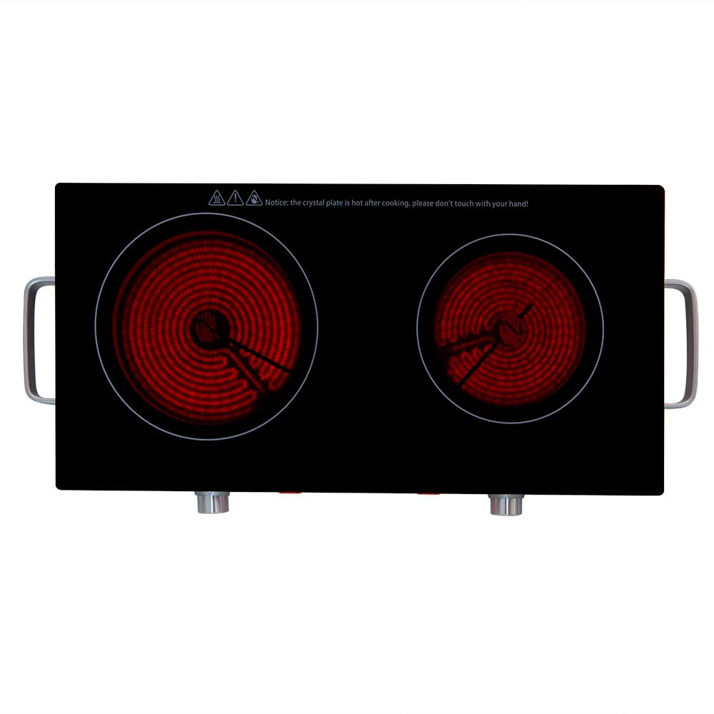 Czarna płyta elektryczna, dwa czerwone palniki. Tekst ostrzegawczy na górze.