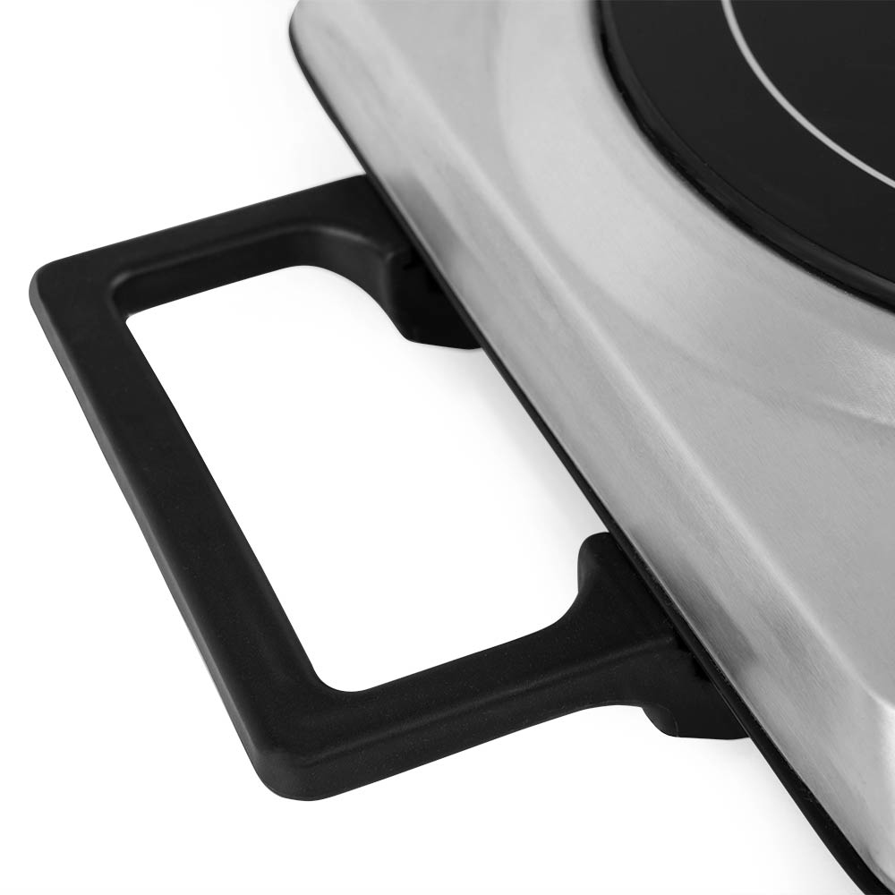 Zbliżenie czarnego uchwytu na srebrnej płycie elektrycznej.