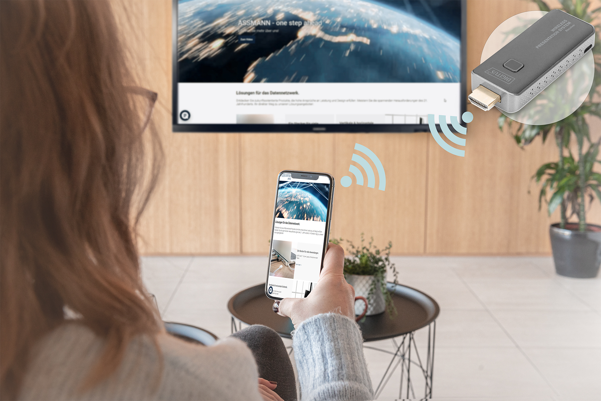 Une personne tient un téléphone, diffusant sur une télévision avec un appareil HDMI sans fil. Fond blanc.