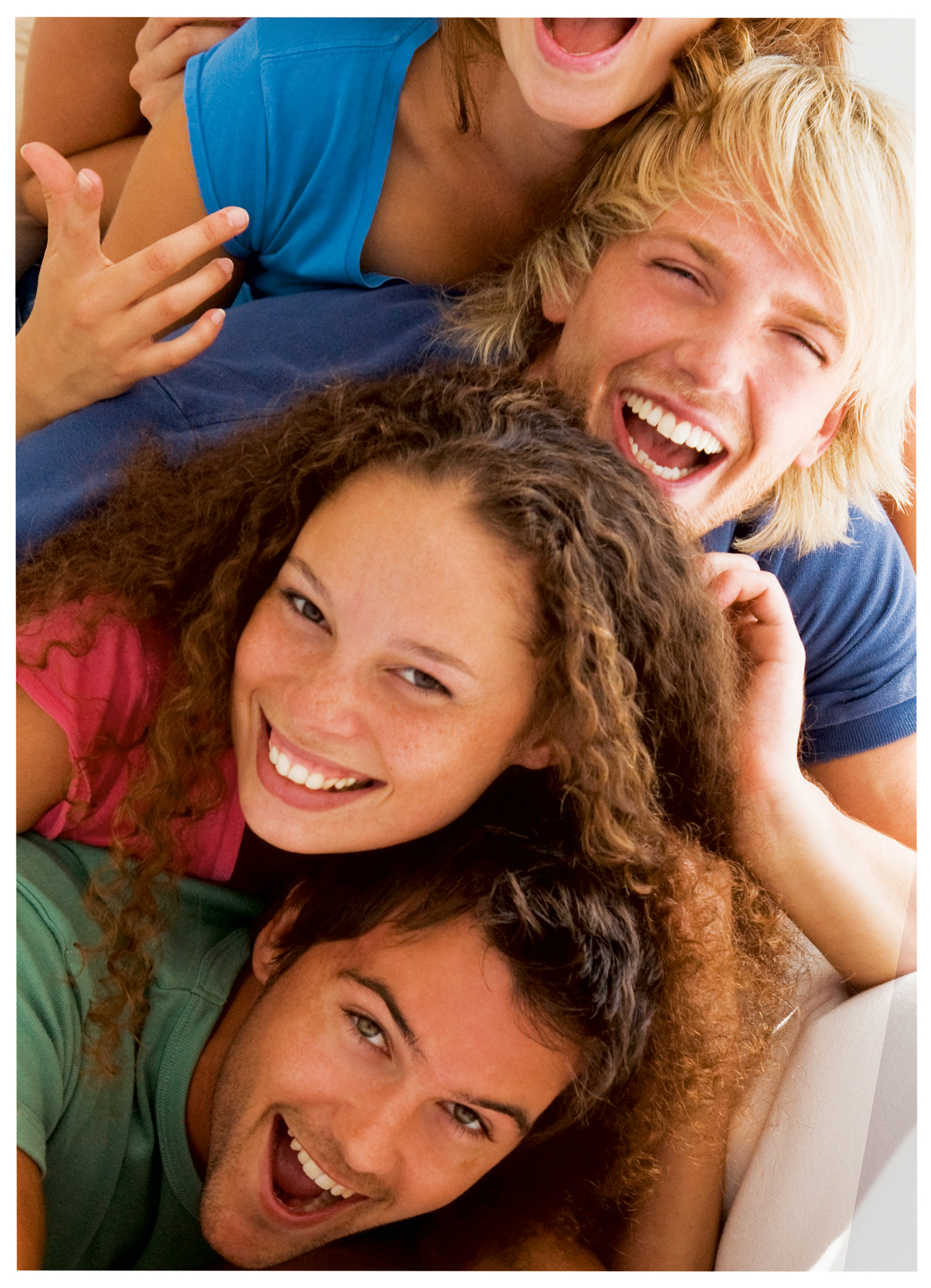 Grupa młodych ludzi uśmiechających się i śmiejących, ułożonych jeden na drugim.