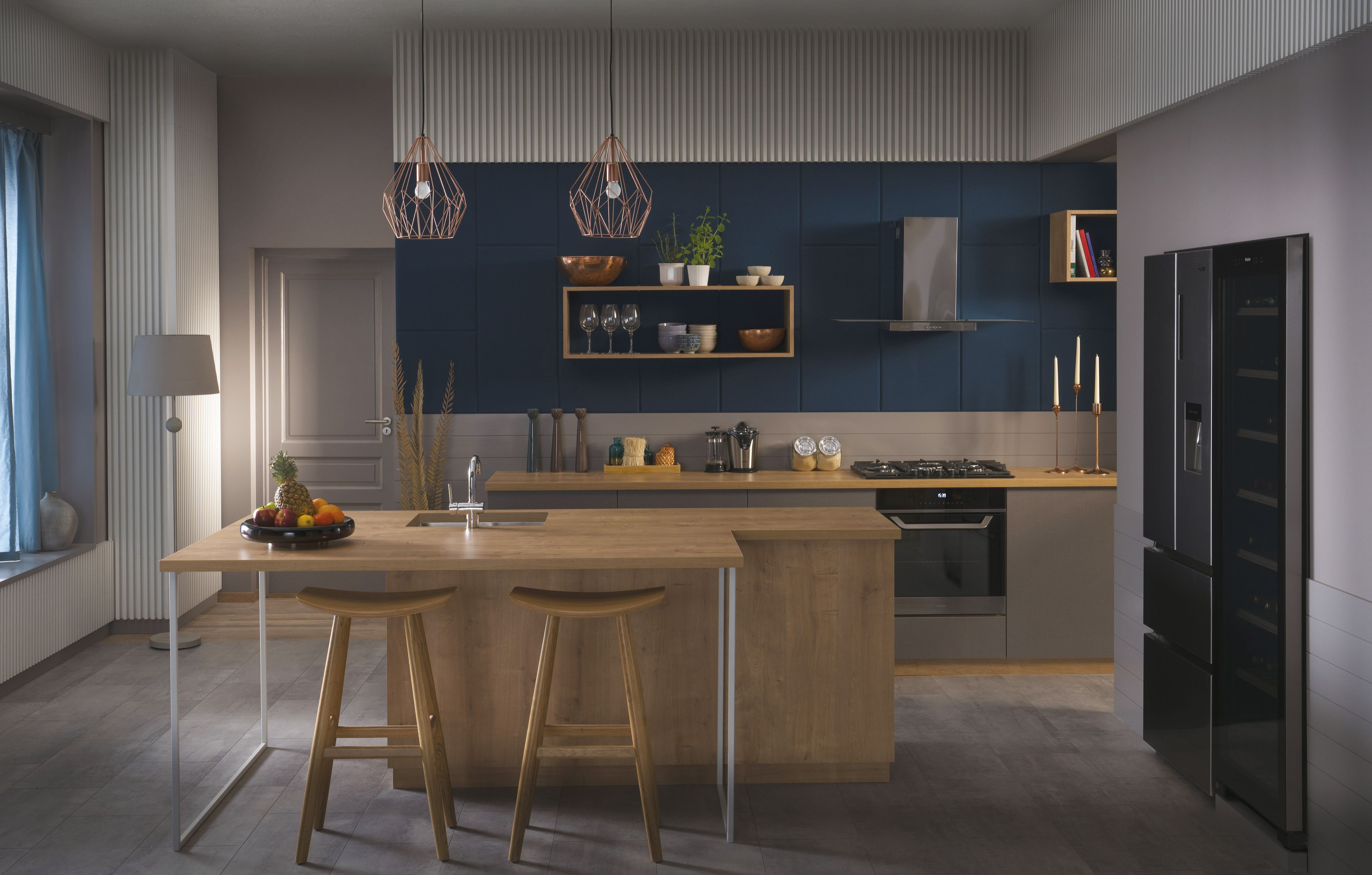 Cocina moderna con isla de madera, taburetes y luces colgantes. Frutas en la isla.