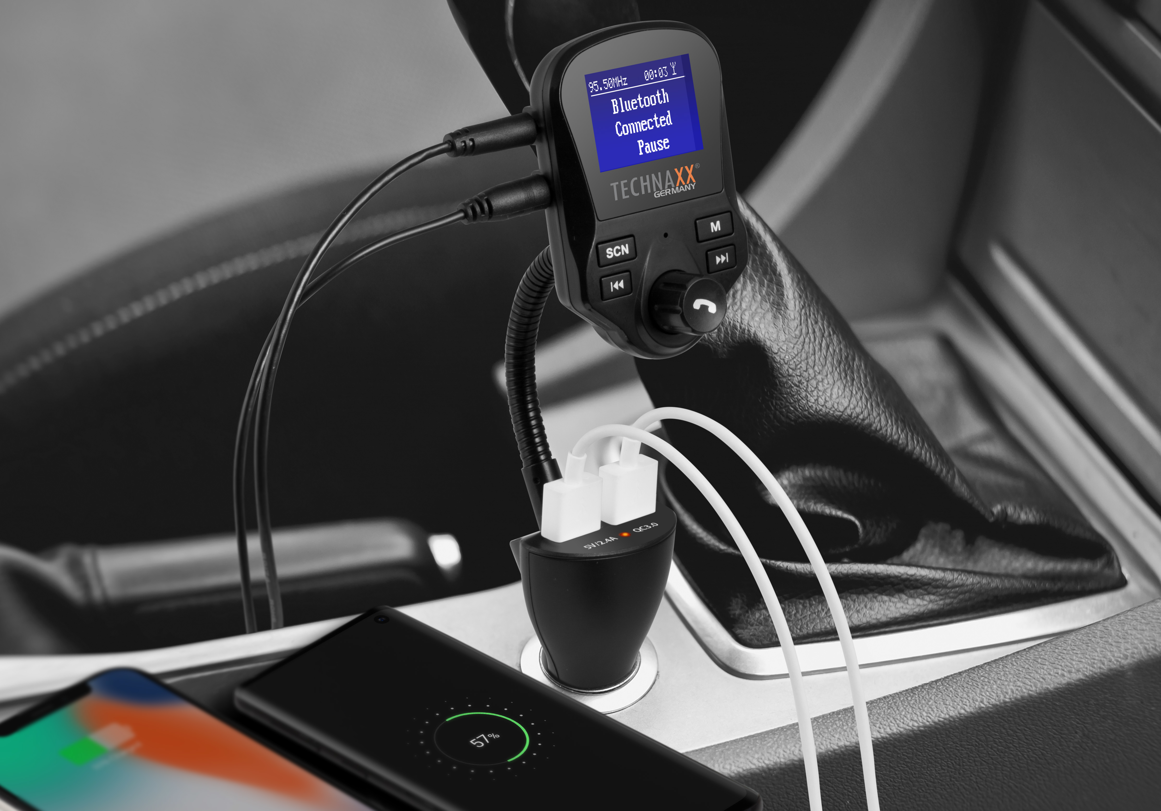 Kfz-Ladegerät mit mehreren USB-Anschlüssen. Ein Telefon lädt. Bluetooth-Anzeige sichtbar.