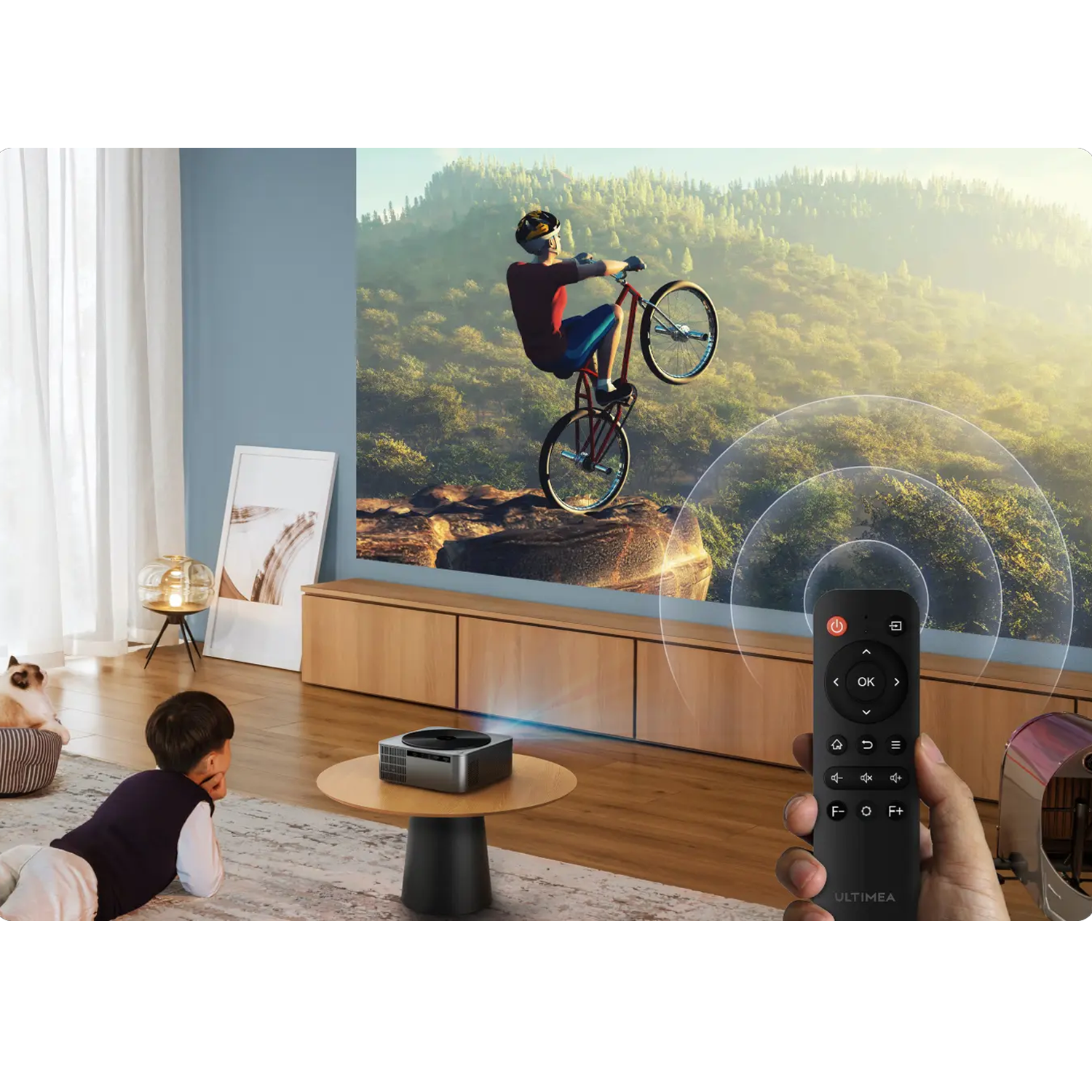 Chłopiec ogląda wyświetlany obraz rowerzysty robiącego wheelie, trzymając pilota.