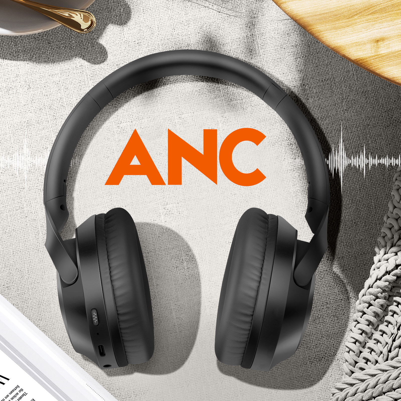 Casque noir sur surface boisée. Texte ANC orange visible.