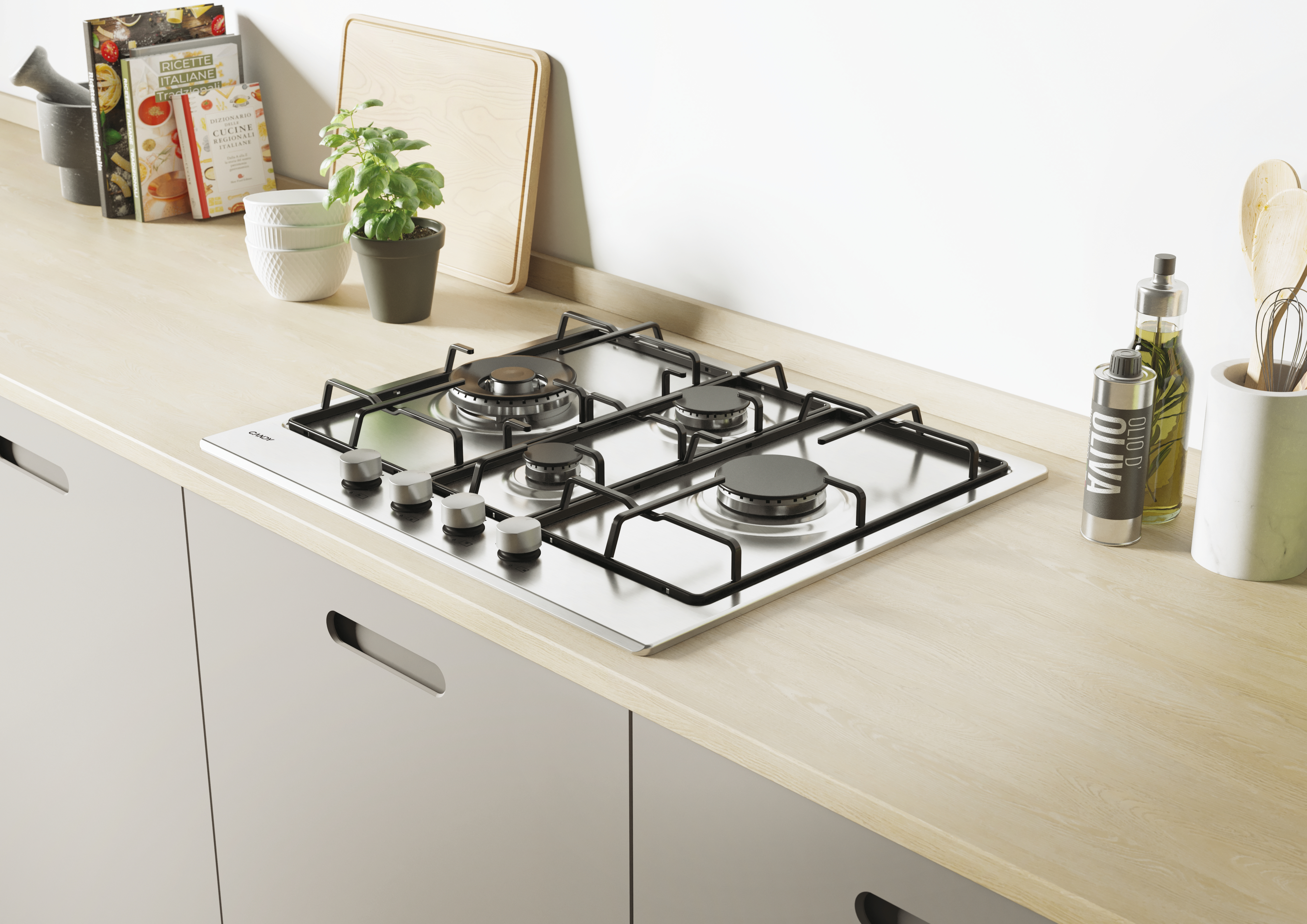 Płyta gazowa ze stali nierdzewnej na drewnianym blacie. Książki, roślina i przybory kuchenne za nią.