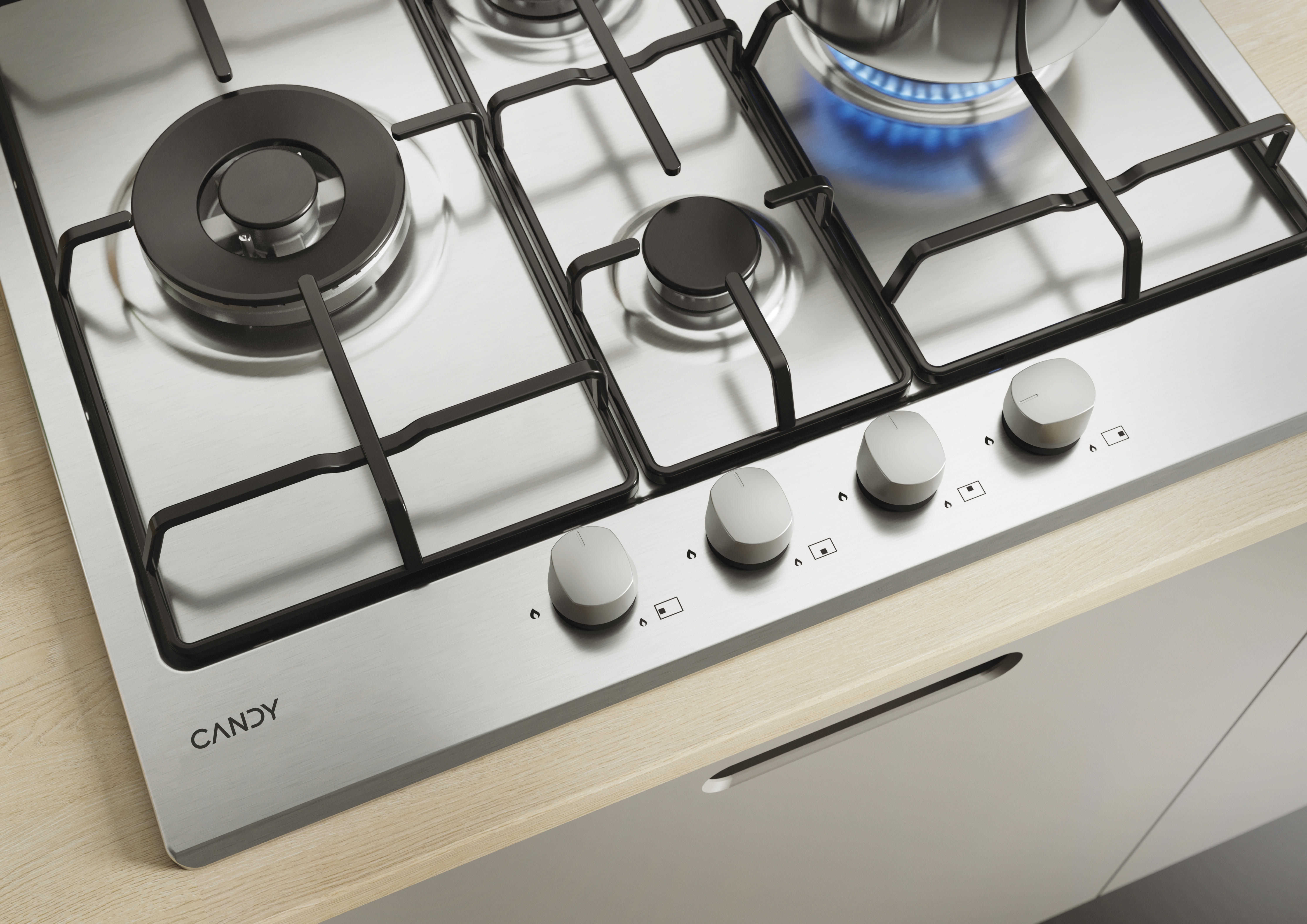Płyta gazowa ze stali nierdzewnej z czterema palnikami i pokrętłami. Widoczna jest marka 'CANDY'.