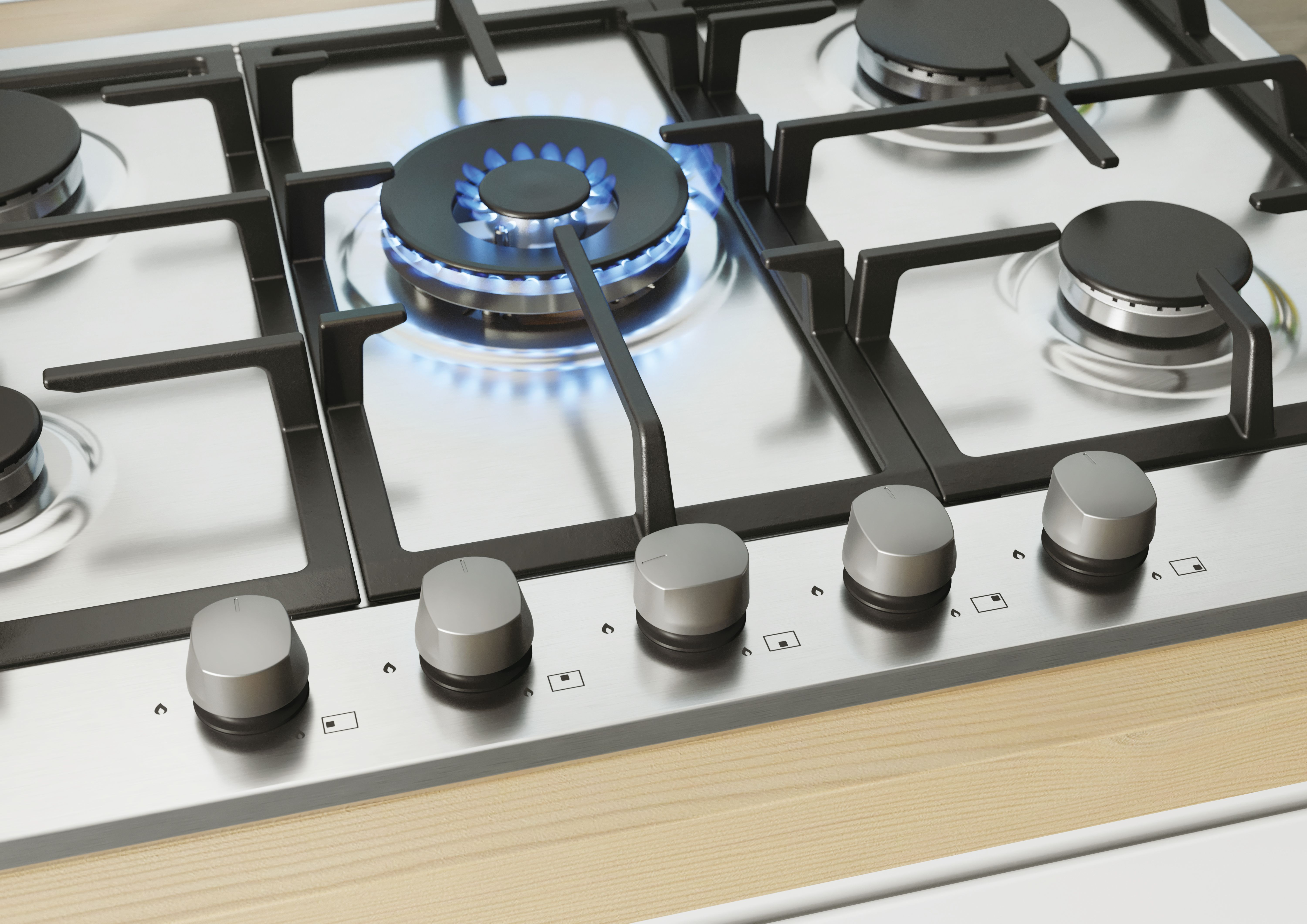 Zbliżenie kuchenki gazowej z palnikami, pokrętłami i powierzchnią ze stali nierdzewnej.