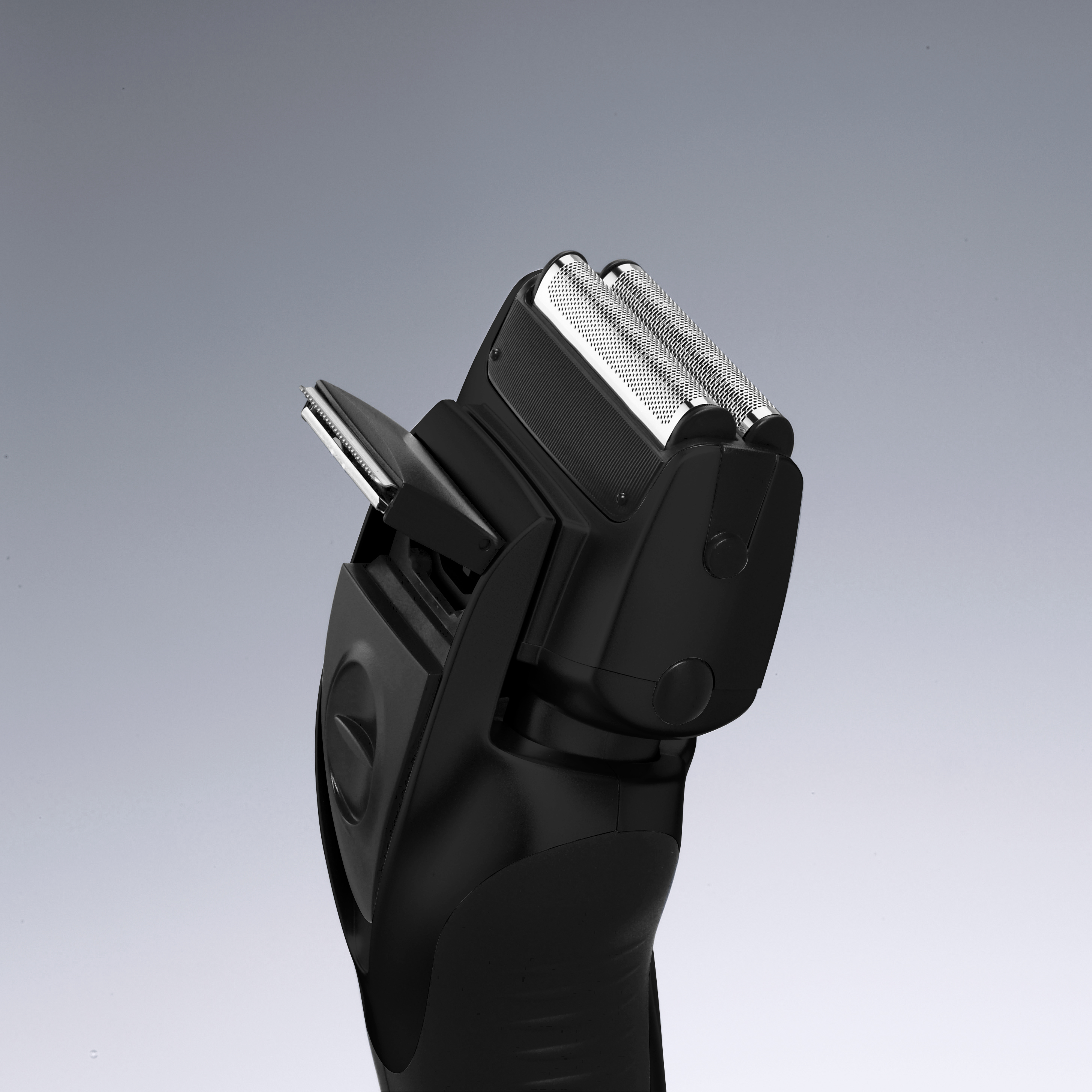 Czarna golarka elektryczna, srebrne ostrza, na szarym tle, ujęcie z bliska.