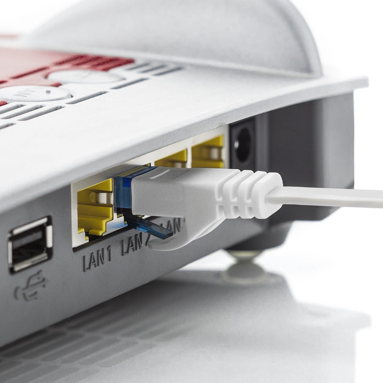Router mit eingestecktem weißen Netzwerkkabel. Kabel ist in LAN1 eingesteckt.