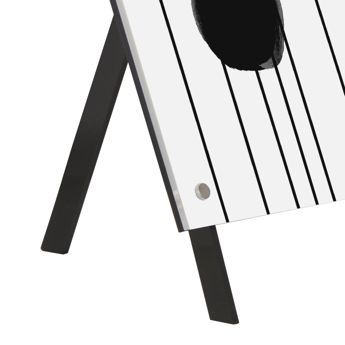 Czarno-biała plansza do cornhole. Czarne nogi i czarne koło na planszy.