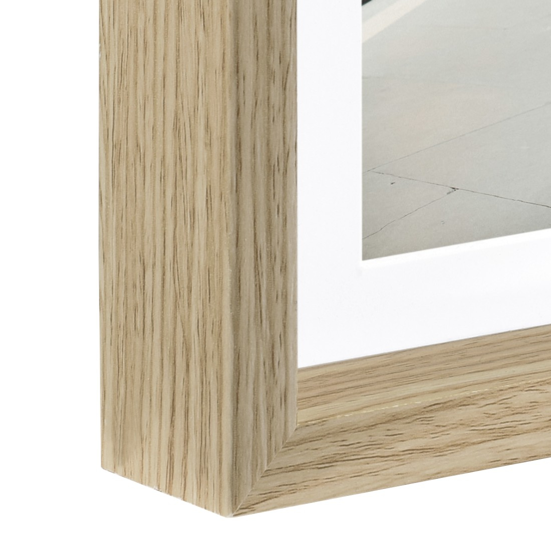 Zbliżenie drewnianej ramy obrazu, pokazujące róg i białe passe-partout.