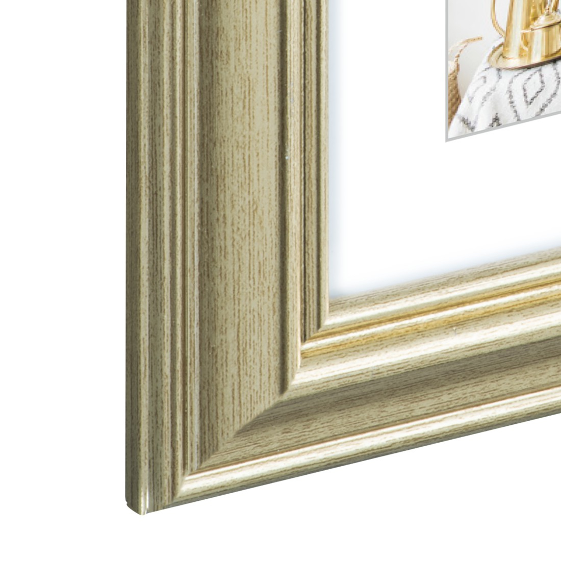 Nahaufnahme einer goldenen Bildecke vor weißem Hintergrund.