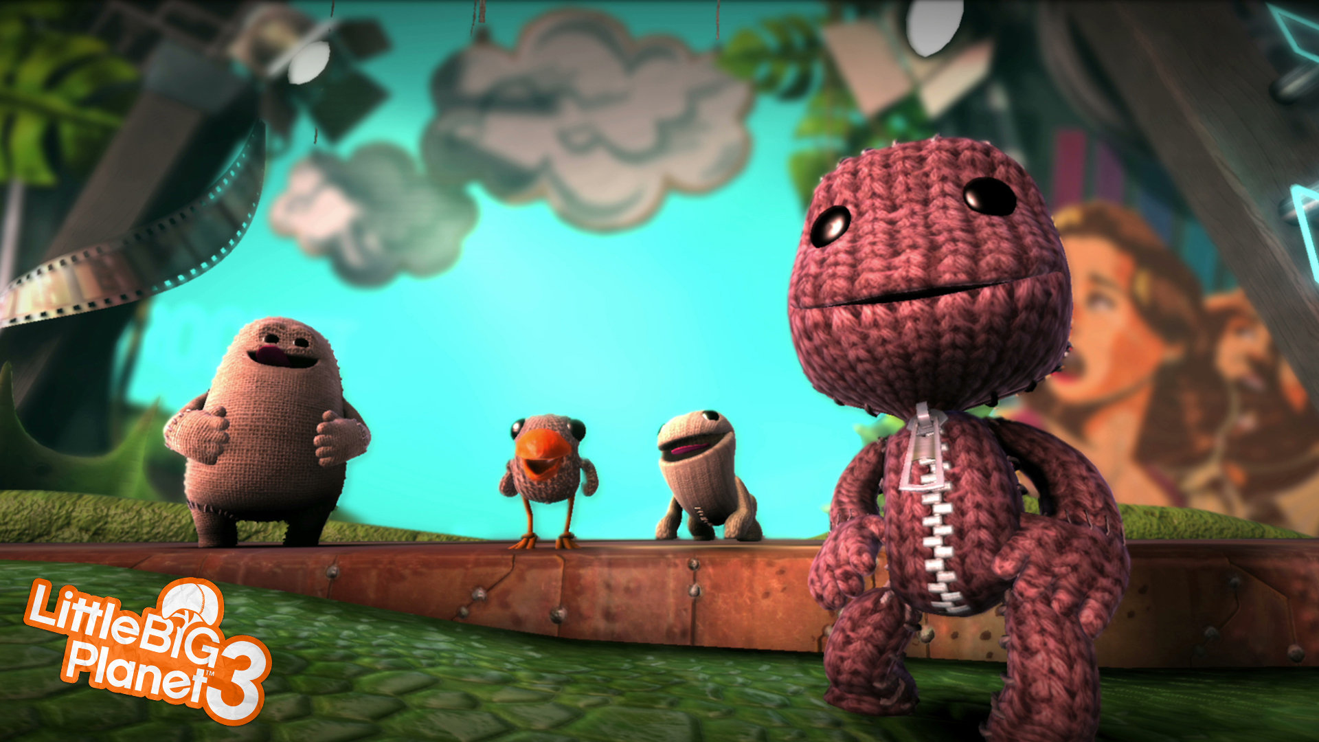 Cuatro personajes de LittleBigPlanet están en una plataforma, con un escenario y la imagen de una mujer en el fondo.