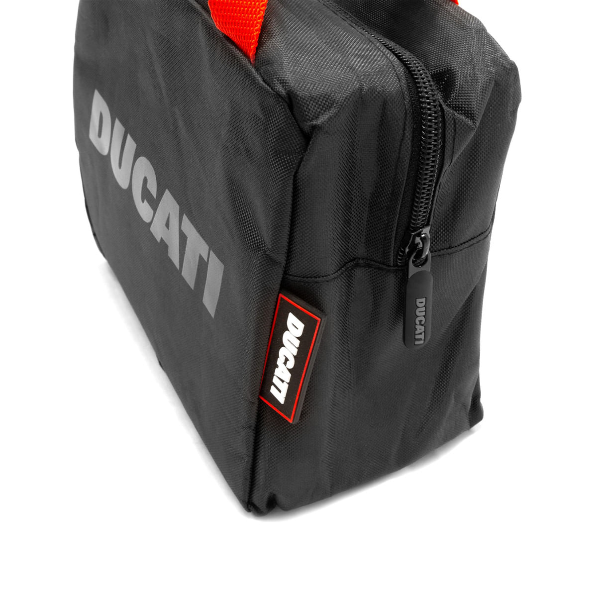 Ducati bag detail. Black bag with zipper. Ducati logo and label. Red tag. White background.