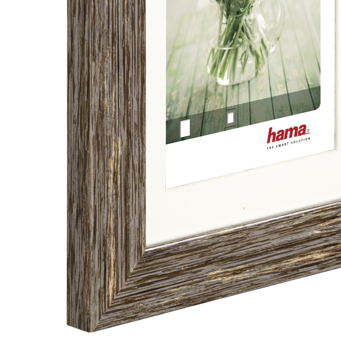 Zbliżenie rogu ramy na zdjęcia, pokazujące fakturę ramy i białą matę.