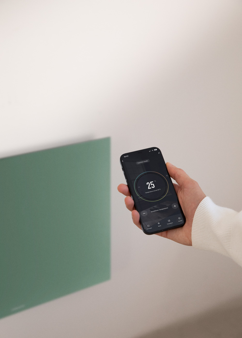 Una mano sostiene un teléfono. La pantalla muestra 25 grados.