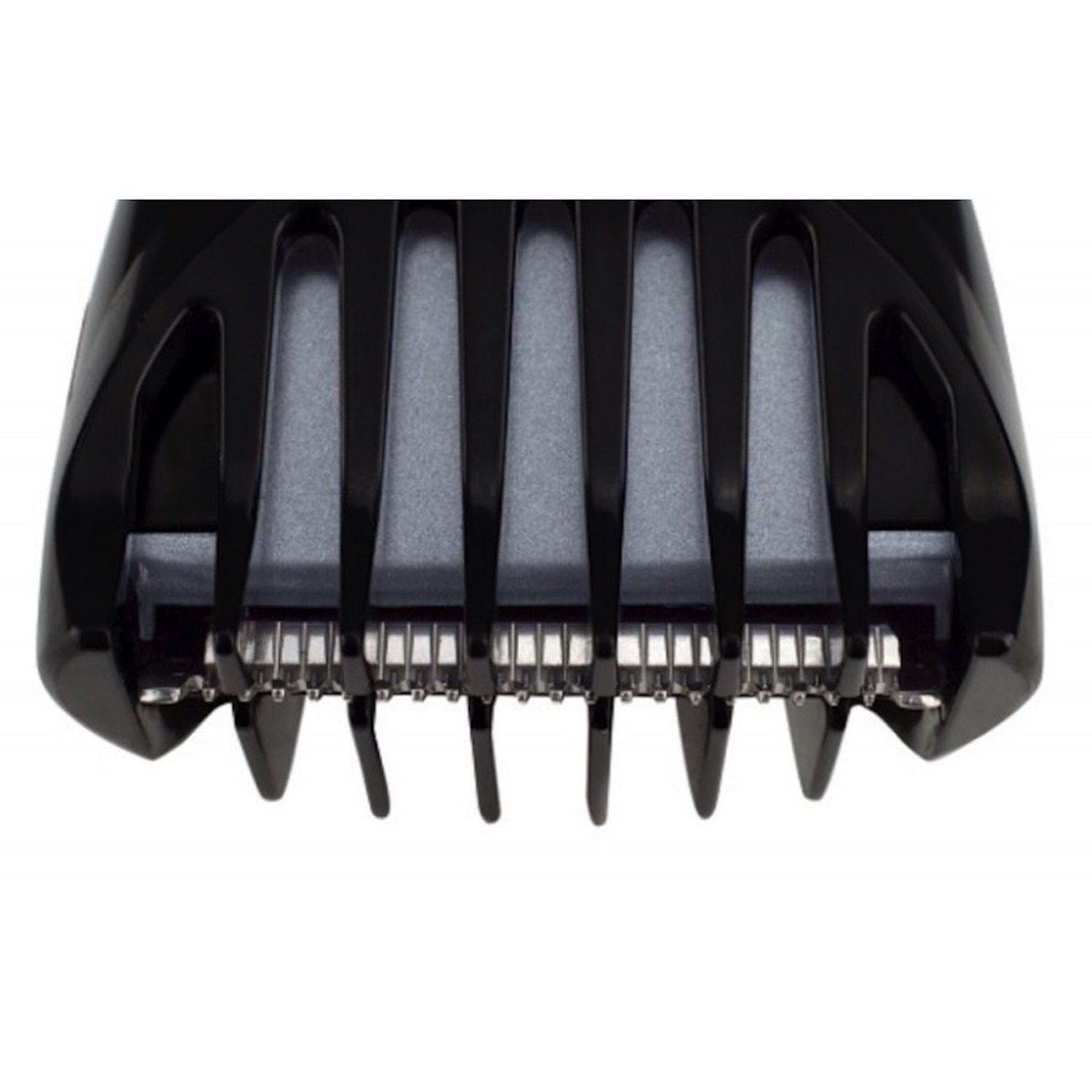 Primer plano de las cuchillas y el protector negros de una recortadora de cabello, vista en ángulo, fondo blanco.