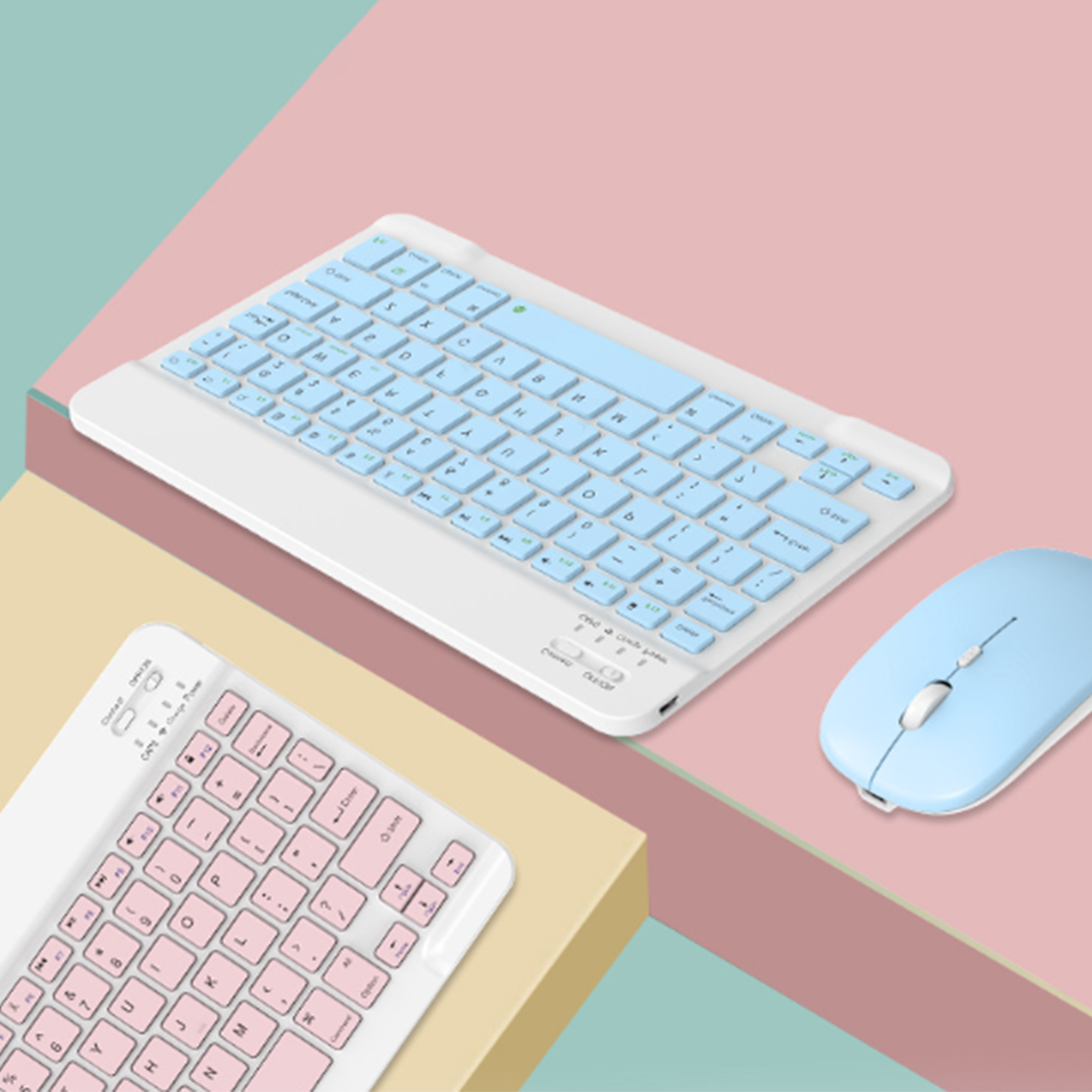 Weiße Tastatur mit blauen Tasten und eine blaue Maus. Eine weitere Tastatur mit rosa Tasten.