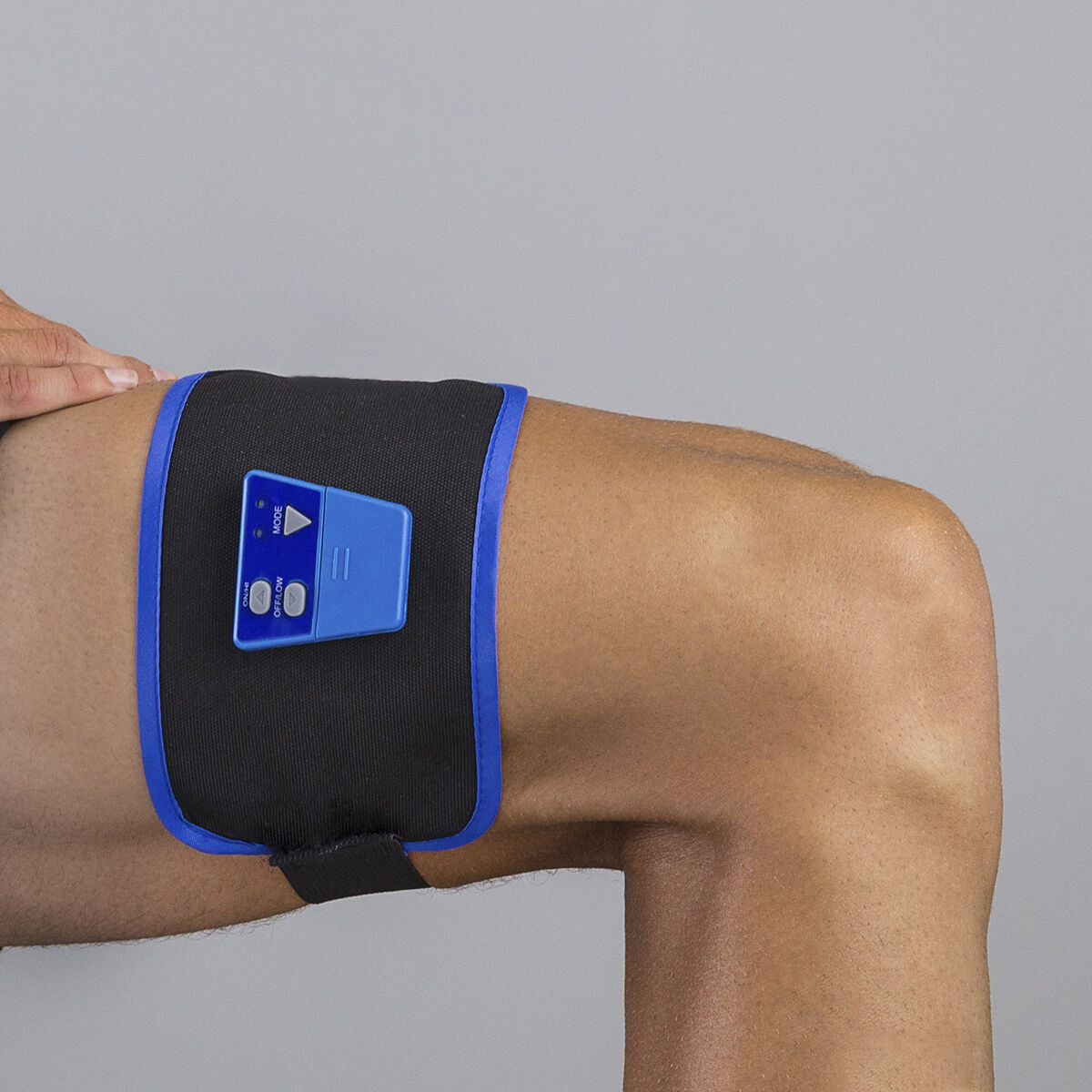 Pierna de persona con dispositivo médico negro y azul alrededor del muslo.