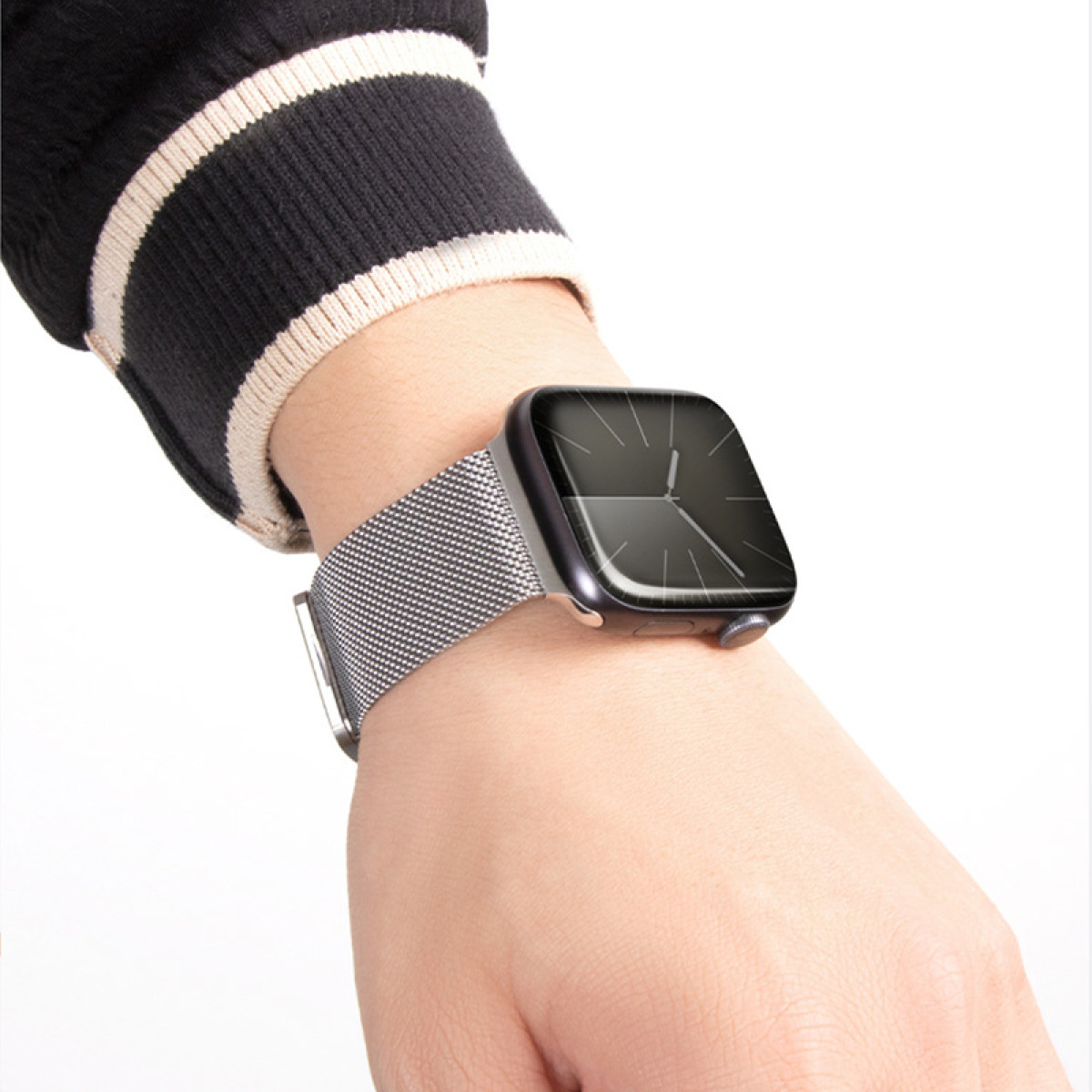 Person trägt eine Smartwatch mit einem Metall-Mesh-Armband.