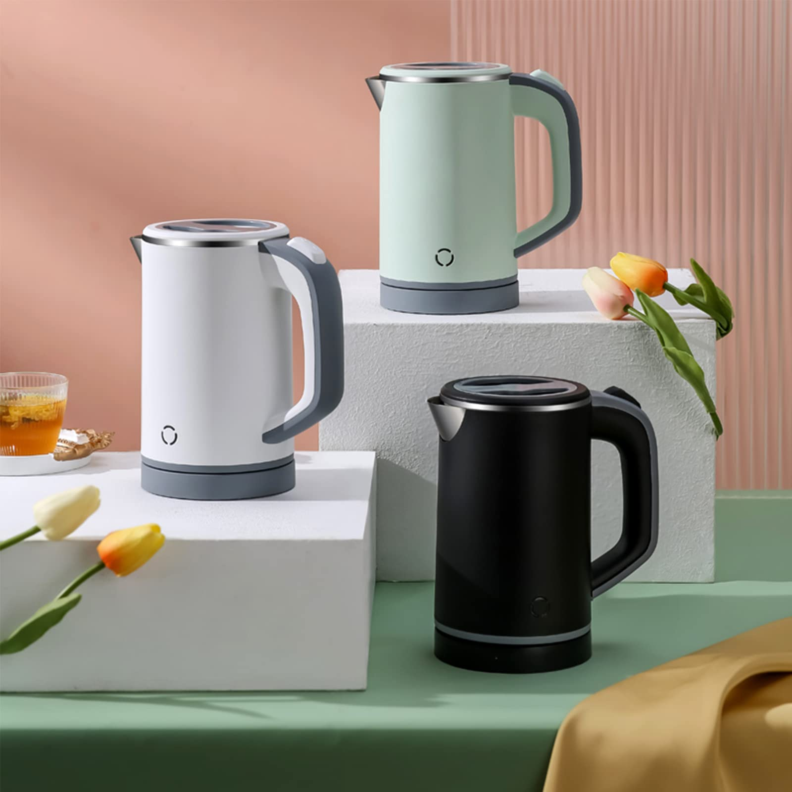Drei elektrische Wasserkocher in Weiß, Grün und Schwarz. Alle haben ähnliche Designs mit Griffen und einem Netzschalter.