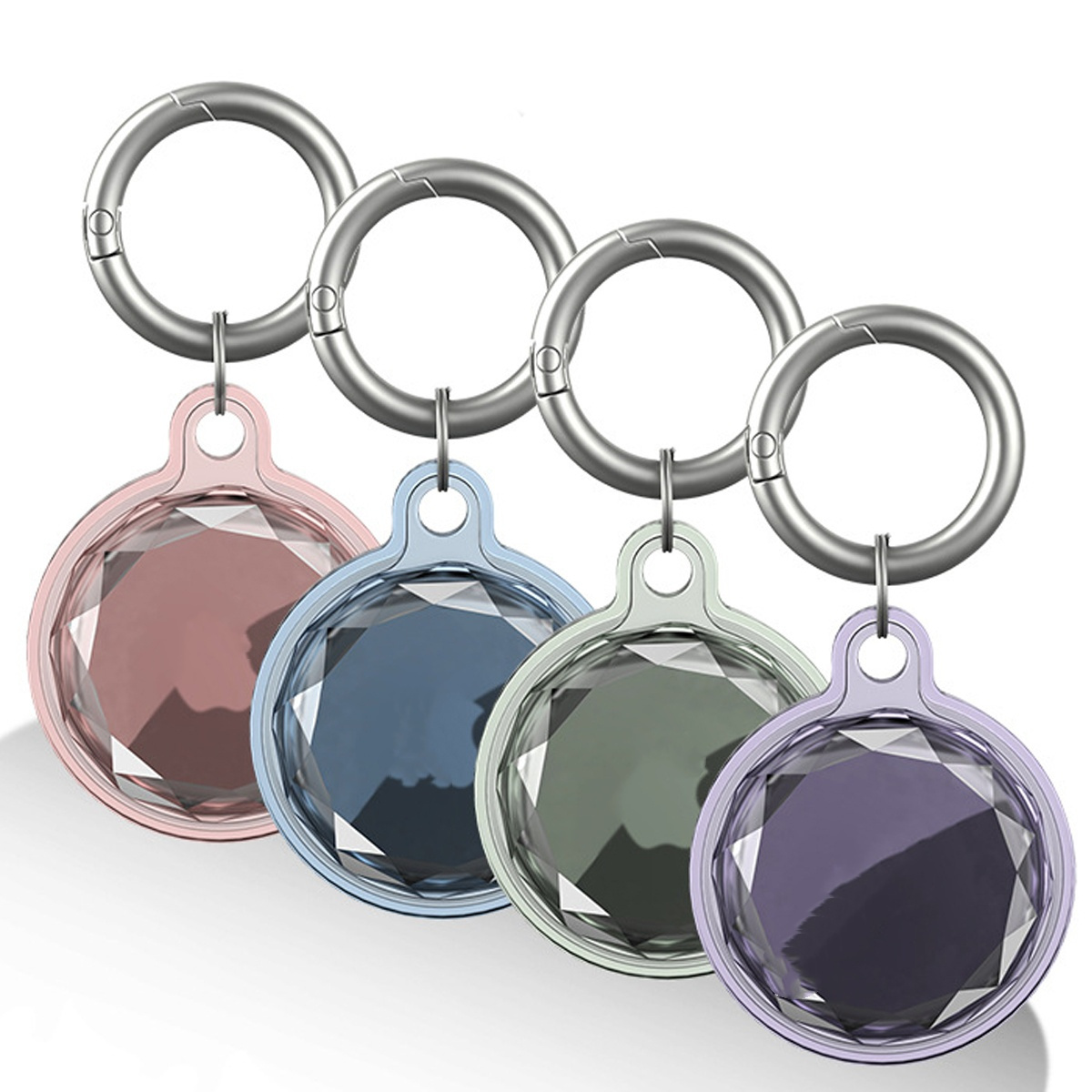 Vier AirTags in verschiedenen Farben, jeweils mit kristallartigem Aussehen und silbernem Ring.
