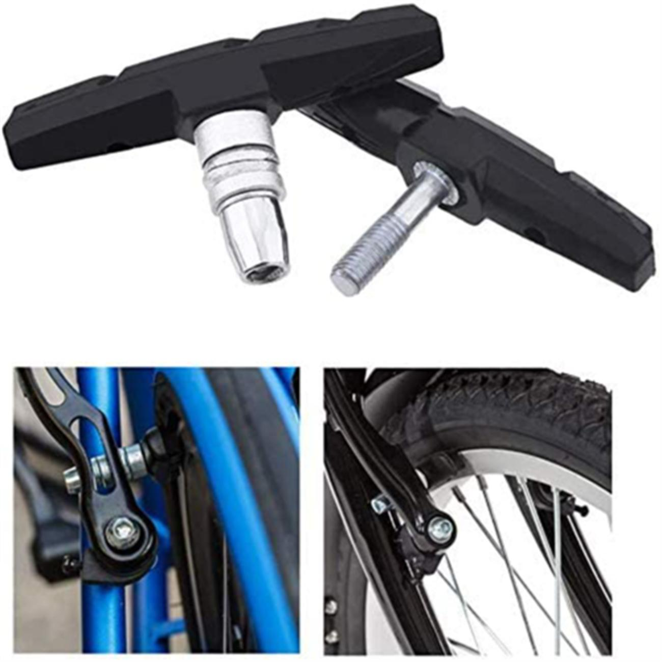 Schwarze Fahrradbremsbeläge mit silbernen Schrauben. Fahrradteile sind im Hintergrund abgebildet.