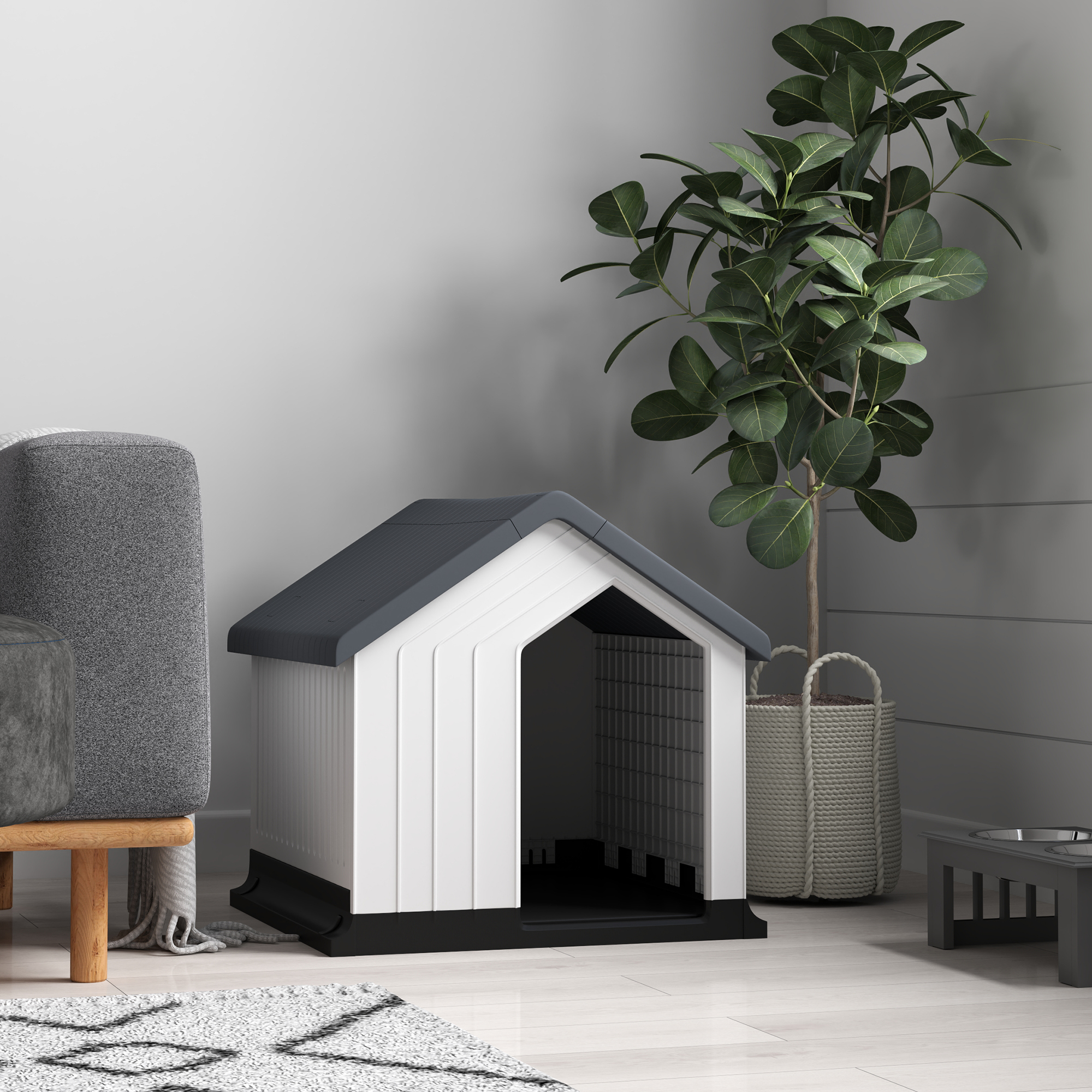 Hundehaus in einem Raum. Ein graues Sofa, eine Pflanze und ein Teppich befinden sich ebenfalls in dem Raum.