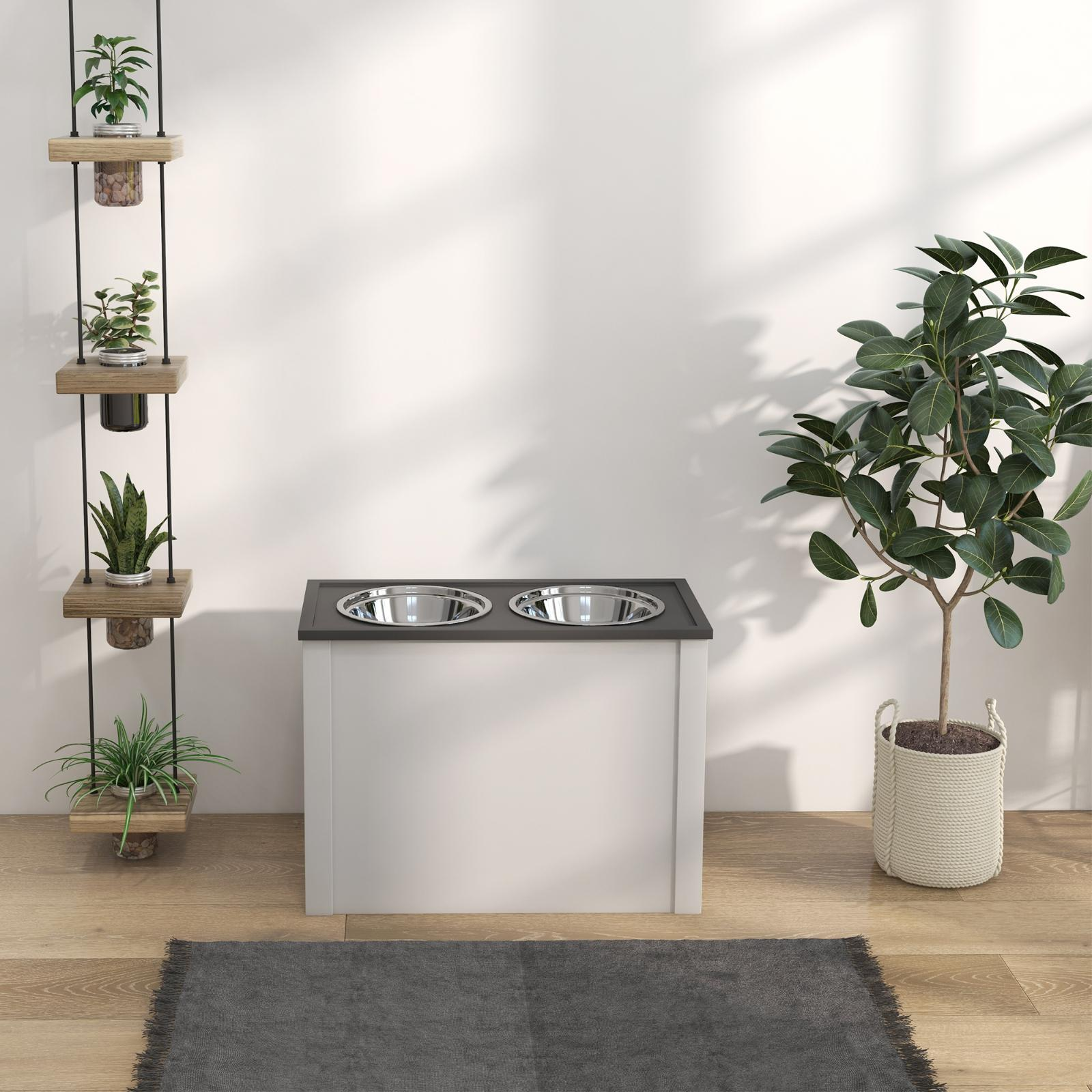 Ein weißer Schrank mit zwei silbernen Schalen, Pflanzen und ein Teppich.