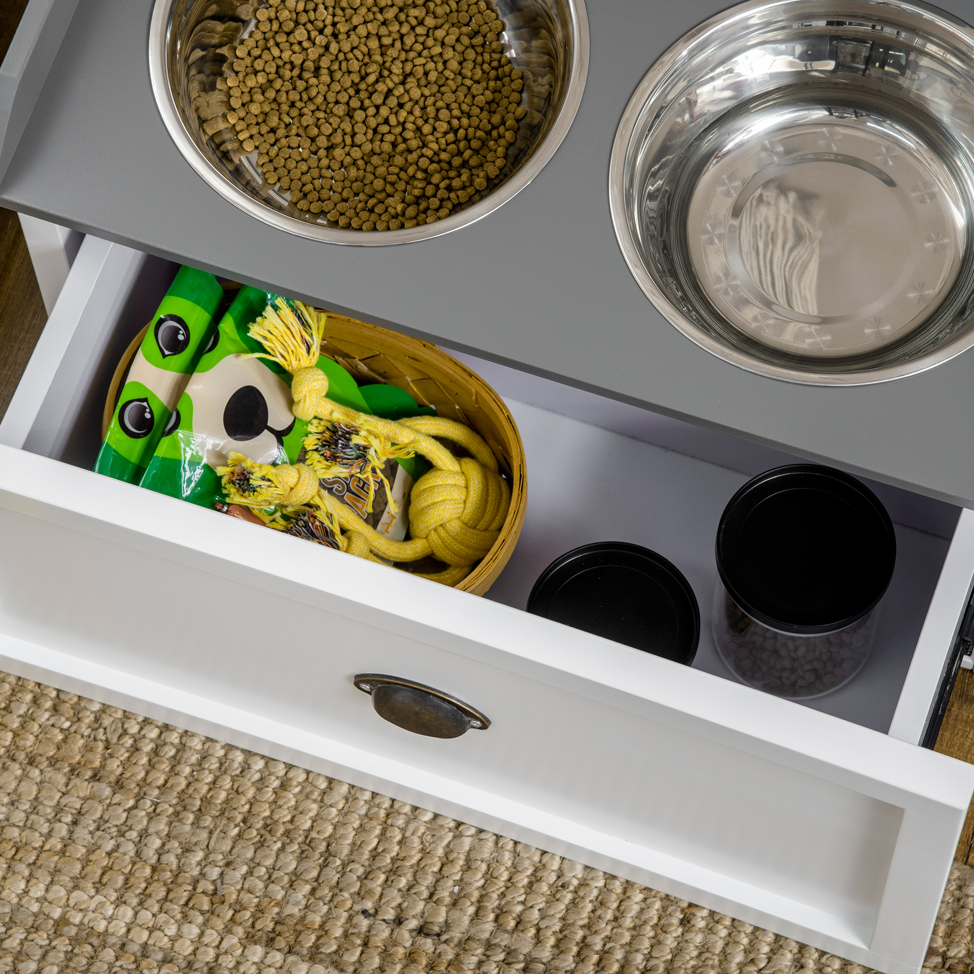 Offene Futterspender-Schublade mit Futter und Spielzeug.