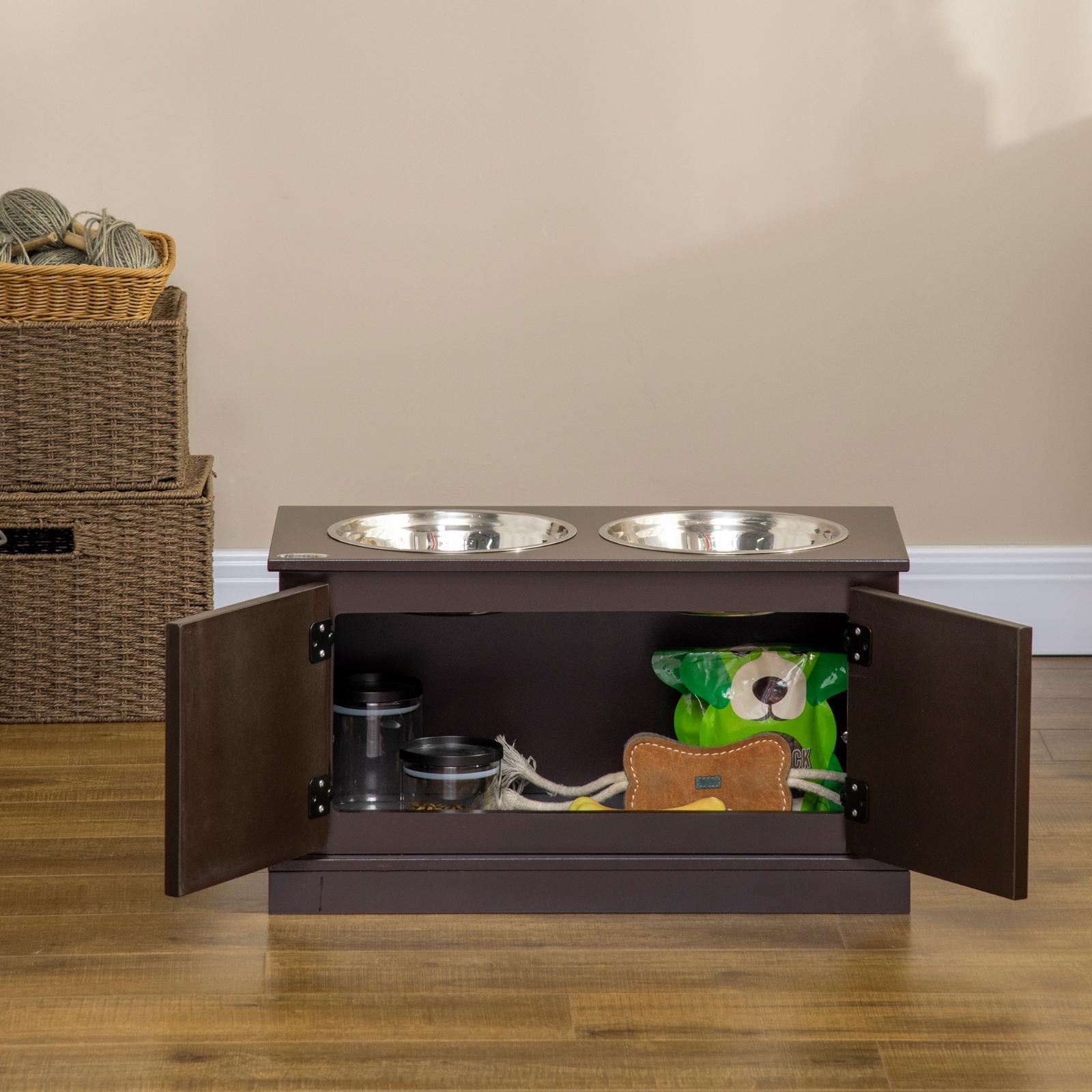 Brauner Schrank mit Edelstahlnäpfen. Türen offen, Hundezubehör wie Spielzeug und Leckerlis werden sichtbar.