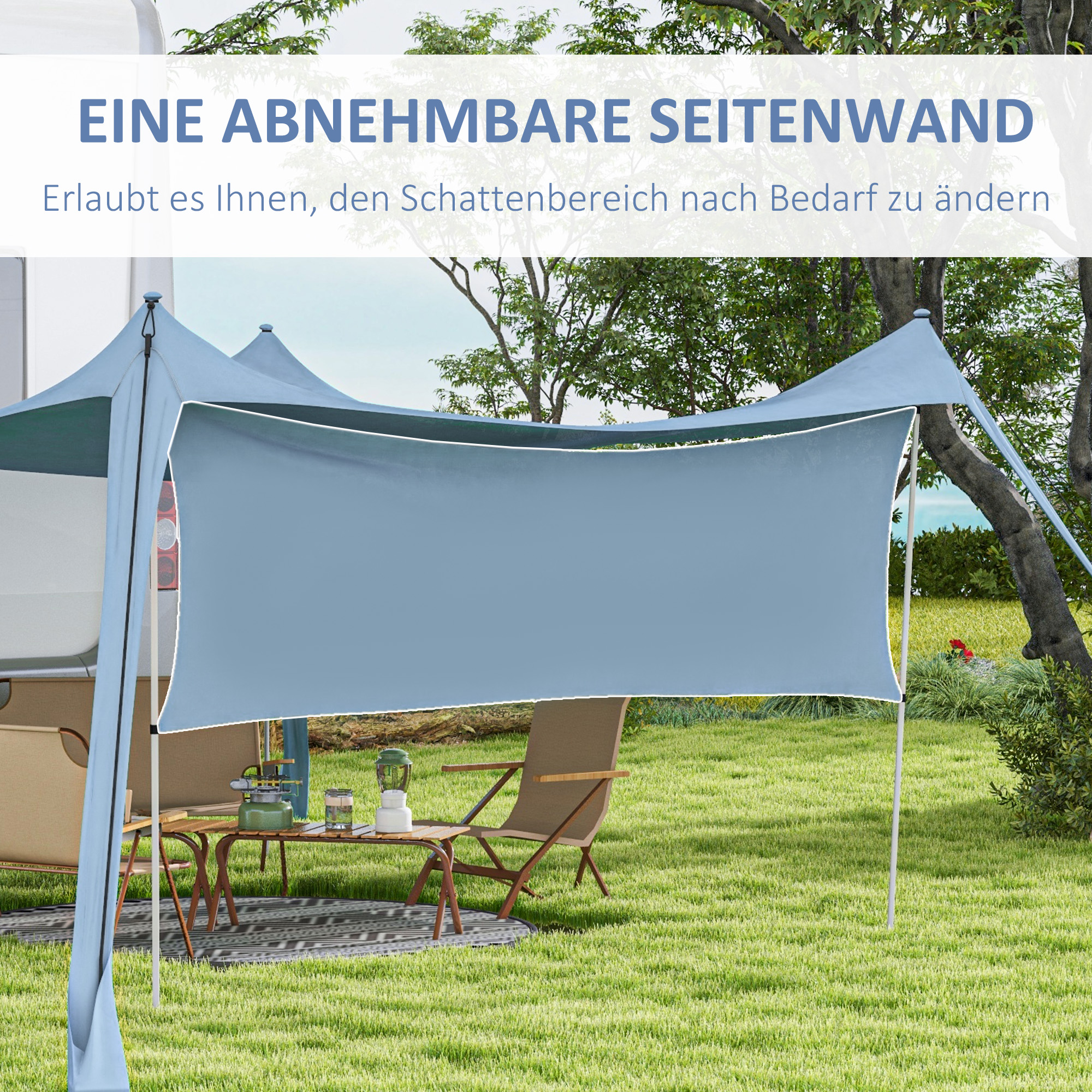 Blaues Vordach mit abgenommenem Seitenteil, Tisch, Stühlen und einem Wohnmobil in einer grünen Umgebung.