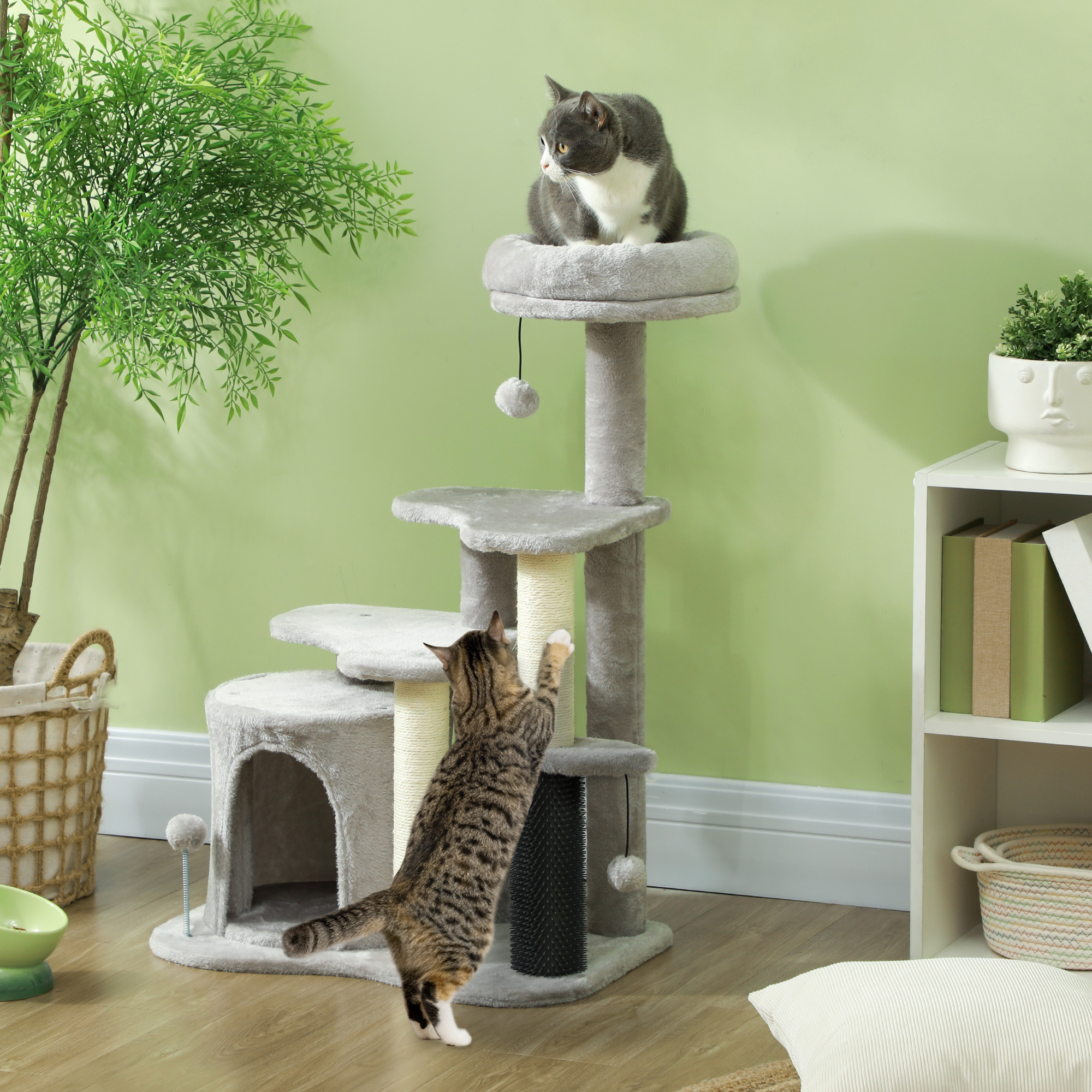 Zwei Katzen auf einem Katzenbaum. Eine Katze ist oben. Die andere Katze kratzt am Pfosten.
