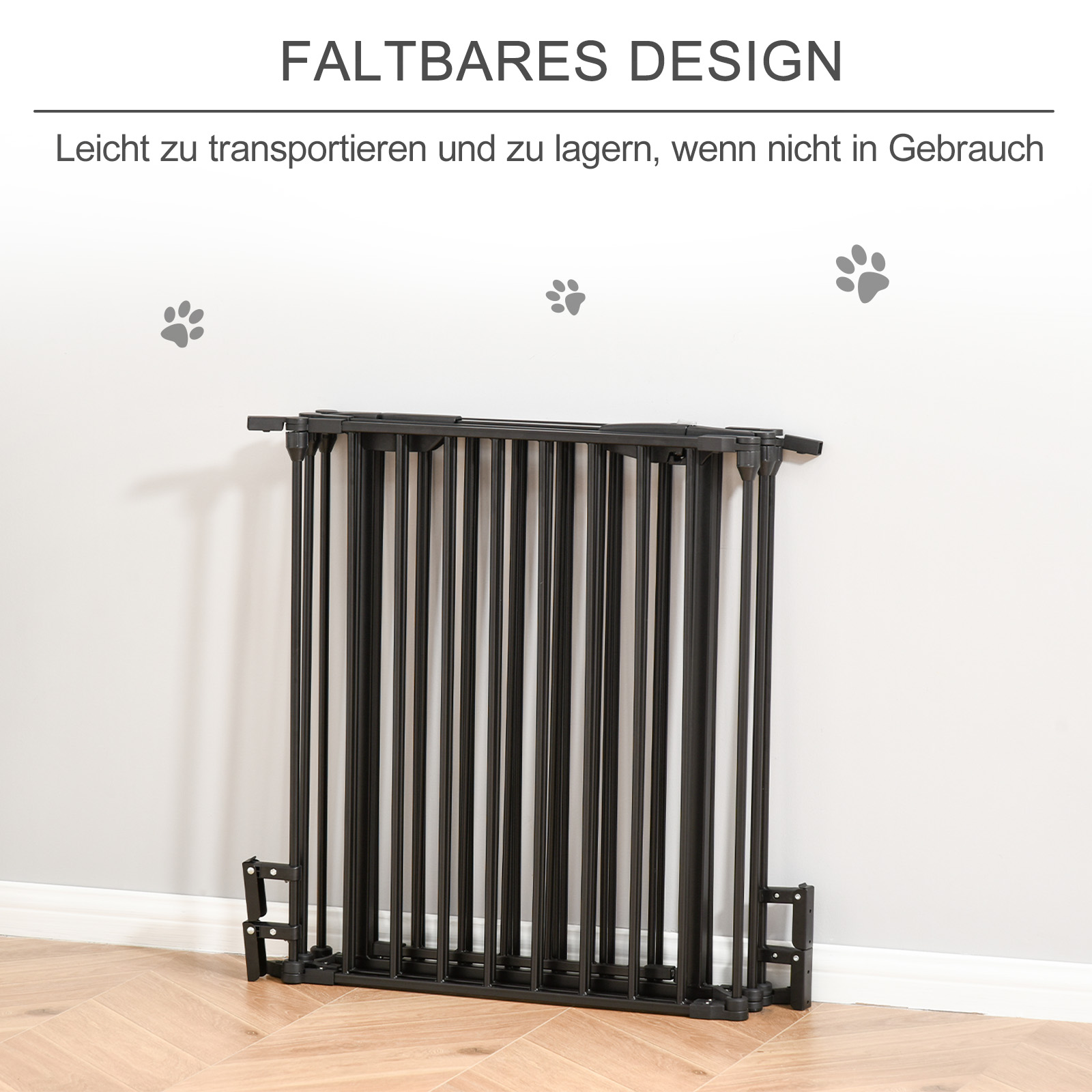 Zusammengeklapptes schwarzes Haustiertor. Graue Wand und Holzboden. Pfotenabdrücke an der Wand.