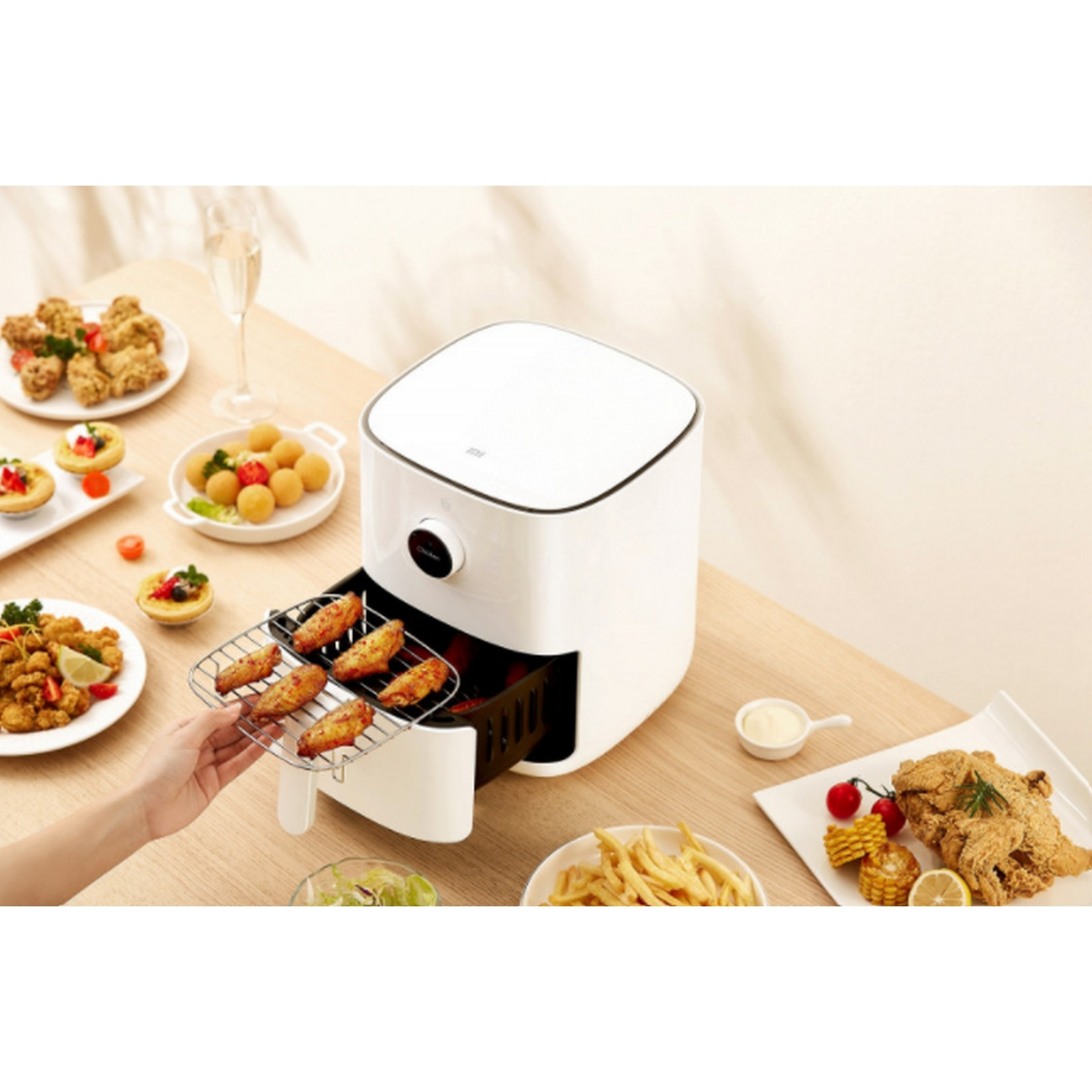 Heißluftfritteuse mit Tabletts voller gebratenem Essen, Hände nehmen Essen heraus.