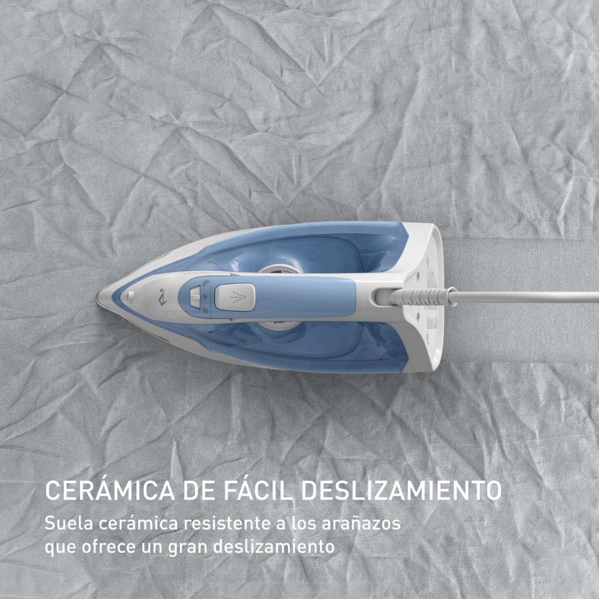 Nahaufnahme eines blau-weißen Bügeleisens auf grauem Stoff, Text lautet 'Cerámica de fácil deslizamiento'.