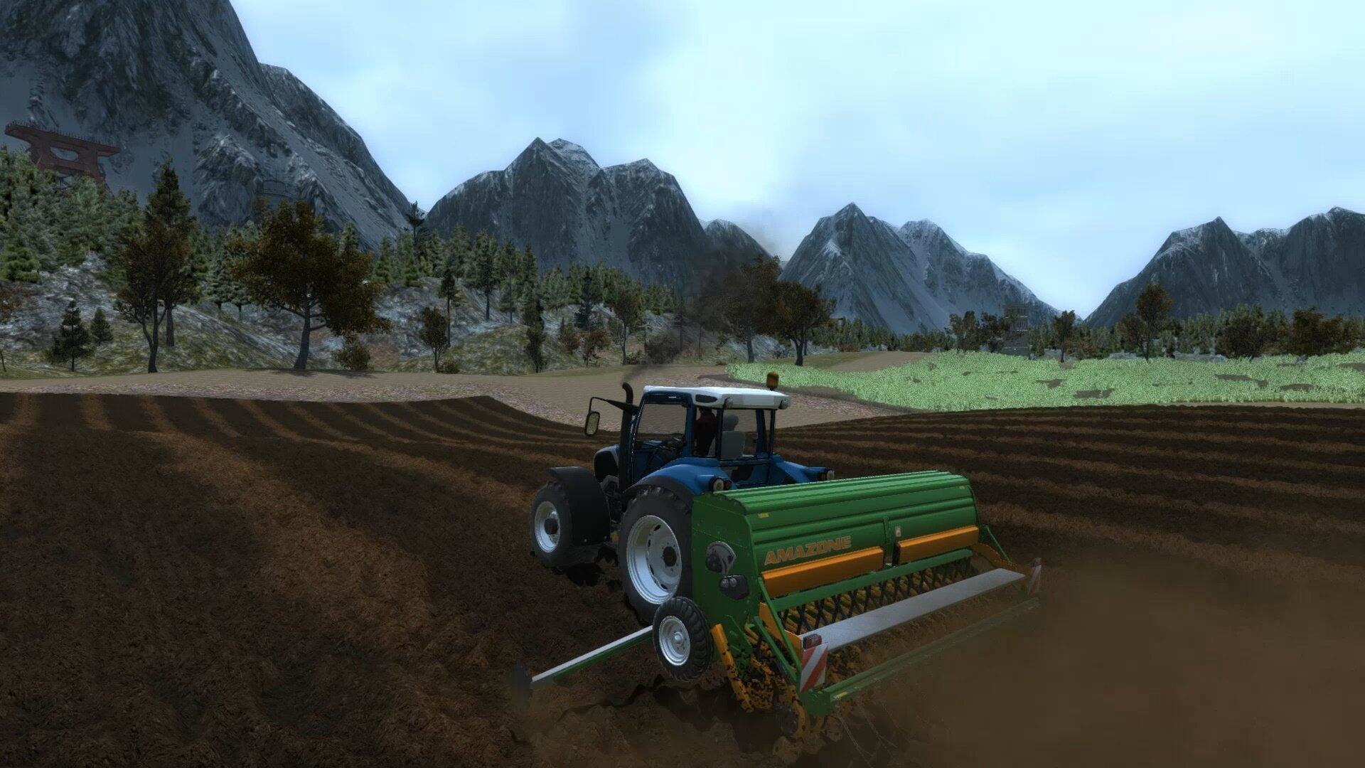 Niebieski traktor z zielonym siewnikiem pracuje na brązowym polu. W tle góry.