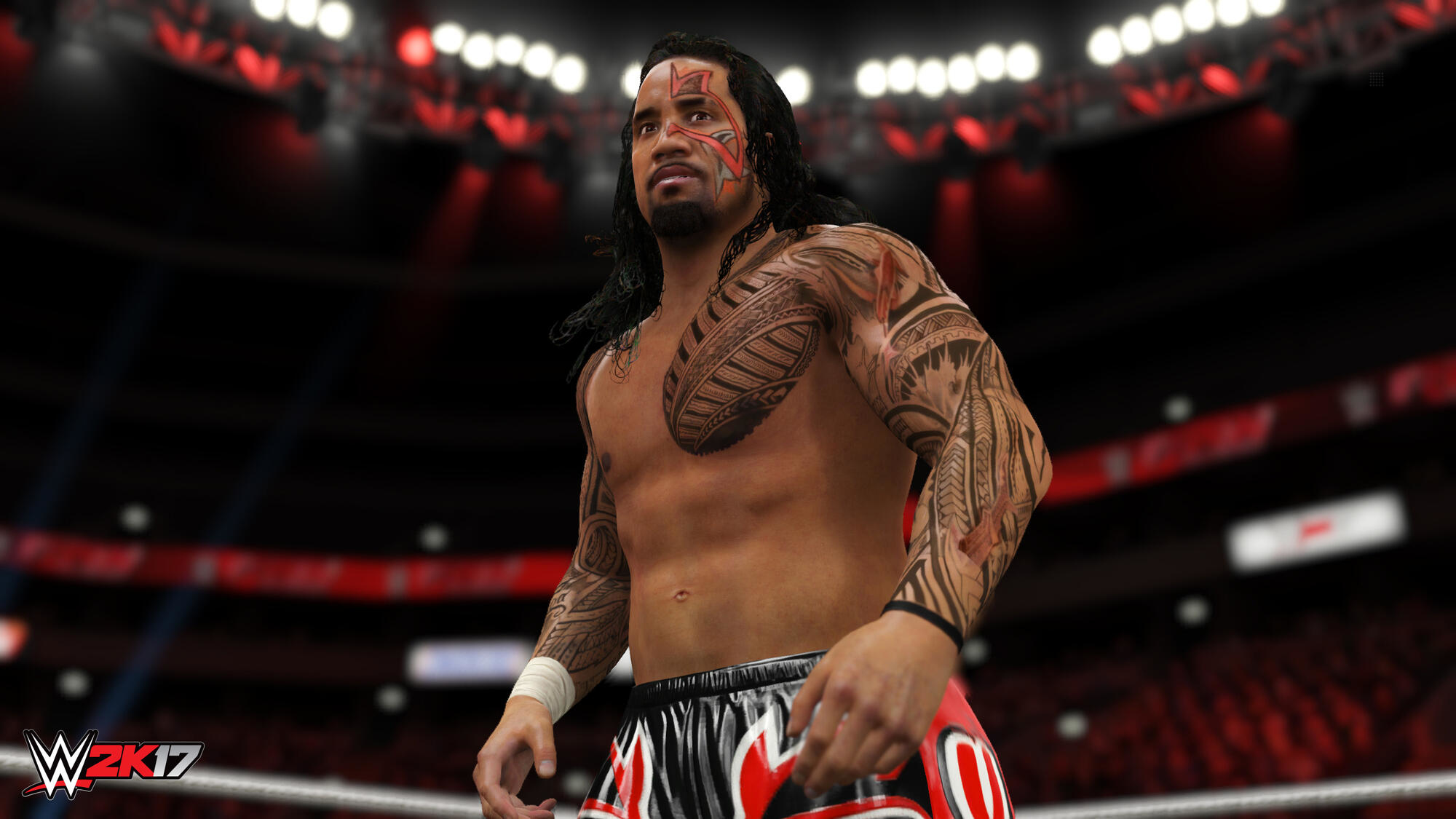 Un luchador está de pie en el ring. Tiene tatuajes y está sin camisa. El logo 'WWE 2K17' es visible.