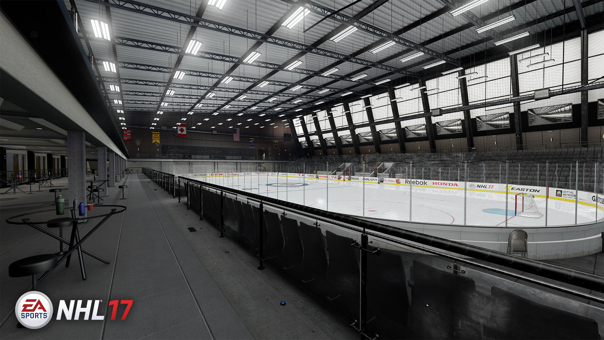Innenraum einer Eishockeyarena mit leeren Sitzen und Eisfläche. Deckenbeleuchtung und Spiel-Branding.