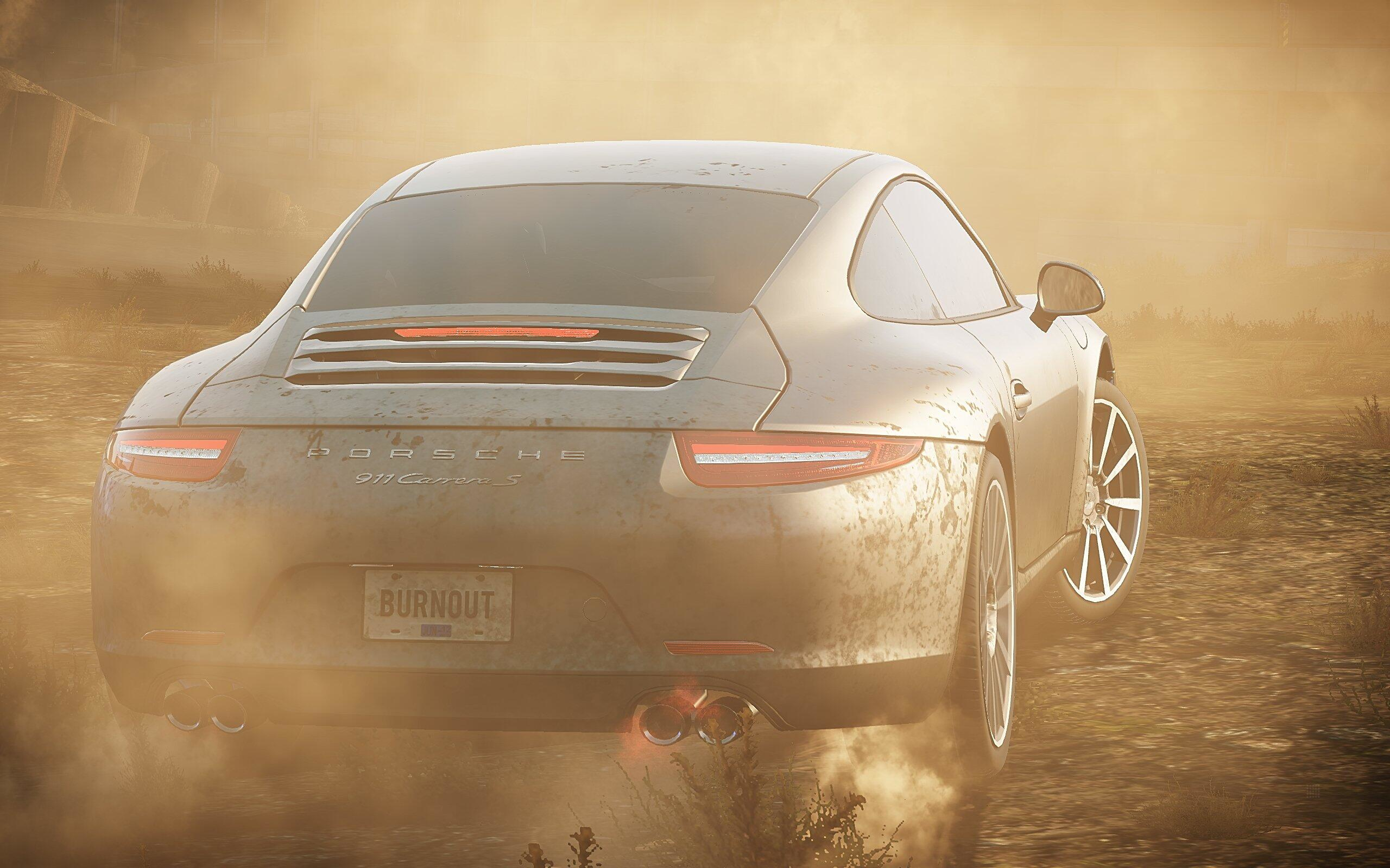 Ein grauer Porsche wirbelt Staub auf einer unbefestigten Straße auf. Das Nummernschild lautet "BURNOUT".