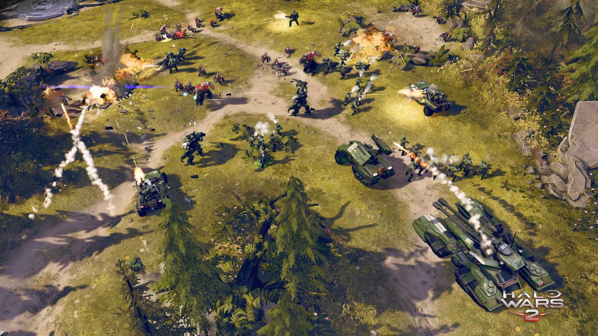 Widok z góry na scenę bitwy z czołgami, żołnierzami i eksplozjami w Halo Wars 2.