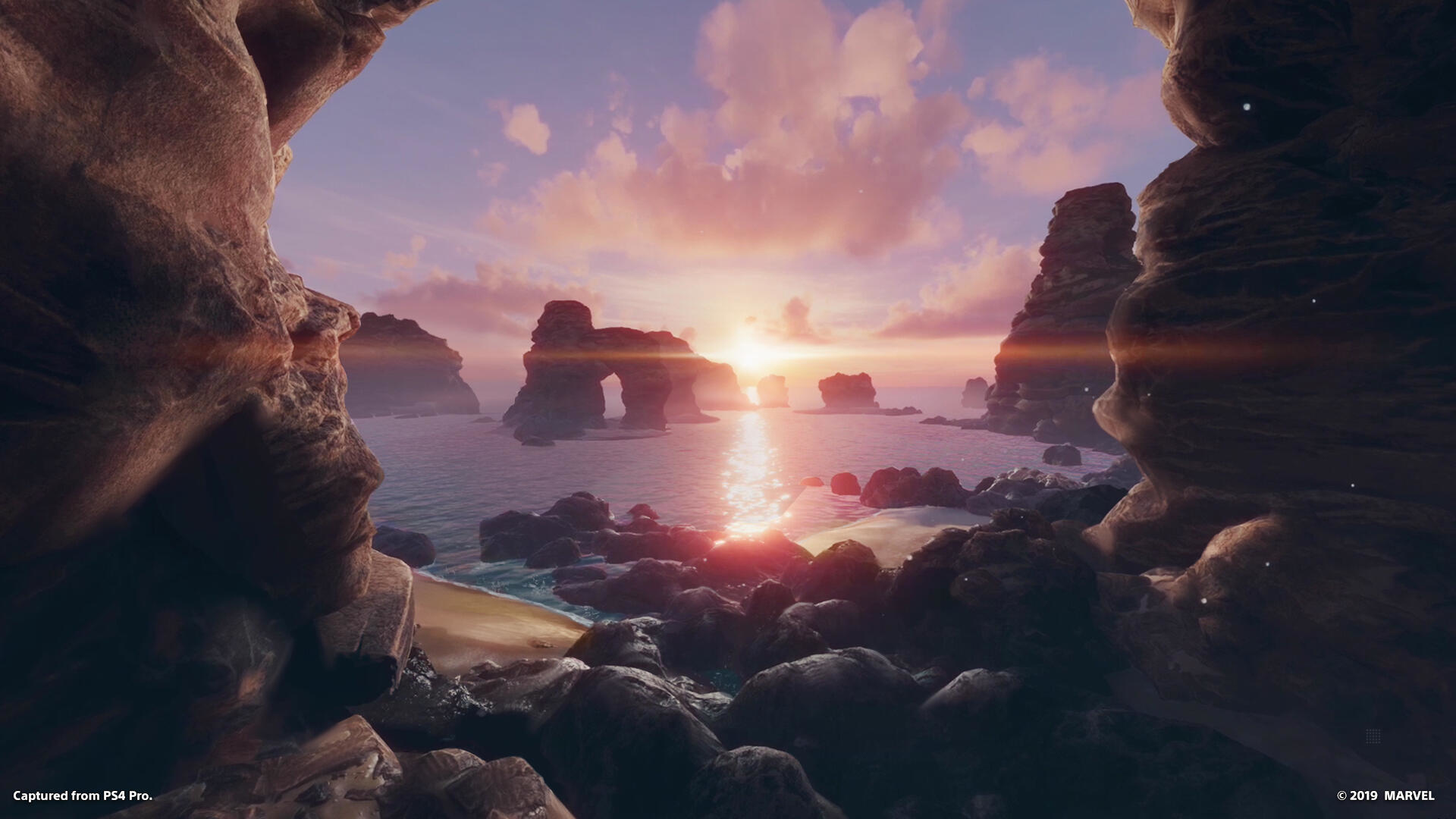 Malowniczy widok przez otwór jaskini. Widoczne są morze, skały i zachód słońca.