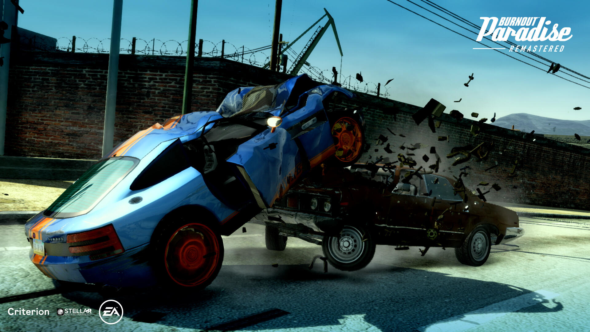 Zderzenie dwóch samochodów, z jednym samochodem do góry nogami. Pokazano tytuł gry "Burnout Paradise Remastered".