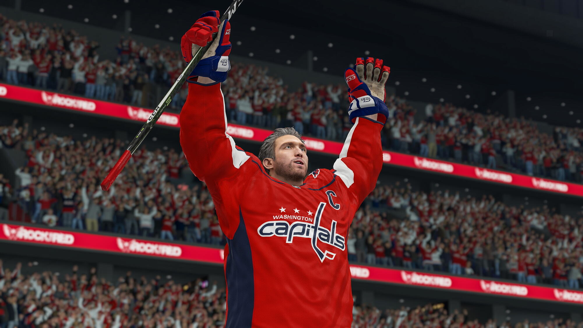 Ein Hockeyspieler in roter Uniform hebt seinen Schläger zum Jubeln. Hintergrund: Menge und Arena.