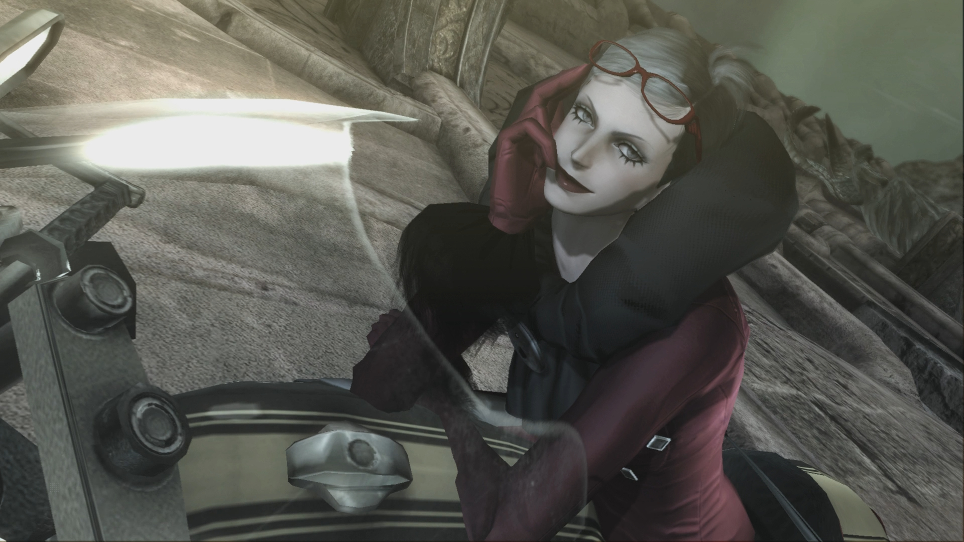 Kobieta obejmuje drugą, trzymając broń. Scena jest intymna, z rozmytym tłem.