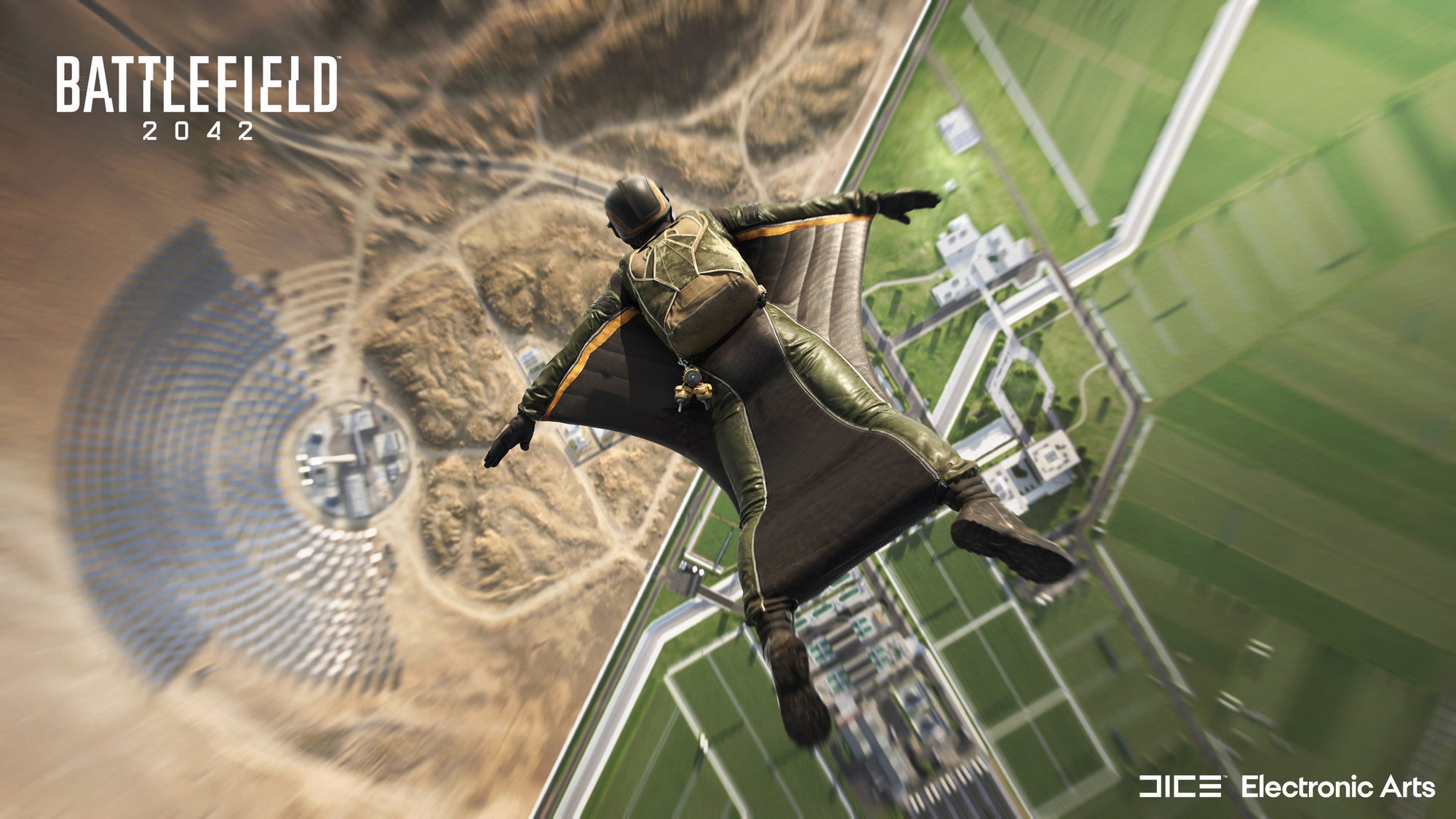 Eine Person in einem grünen Anzug fliegt mit einem Wingsuit über einer Wüstenlandschaft.