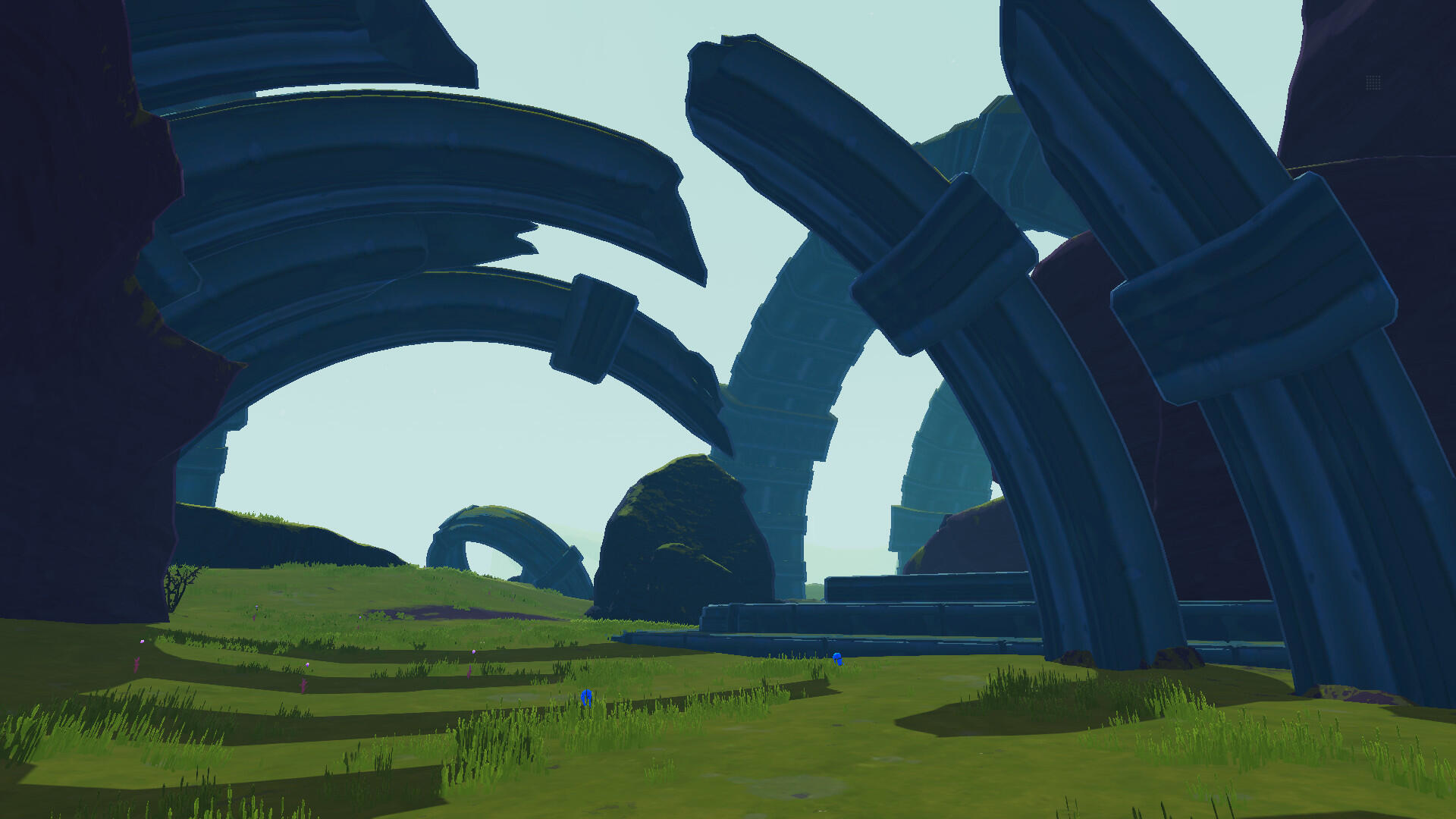 Abstrakcyjny krajobraz z dużymi strukturami łukowymi i zielonym terenem.