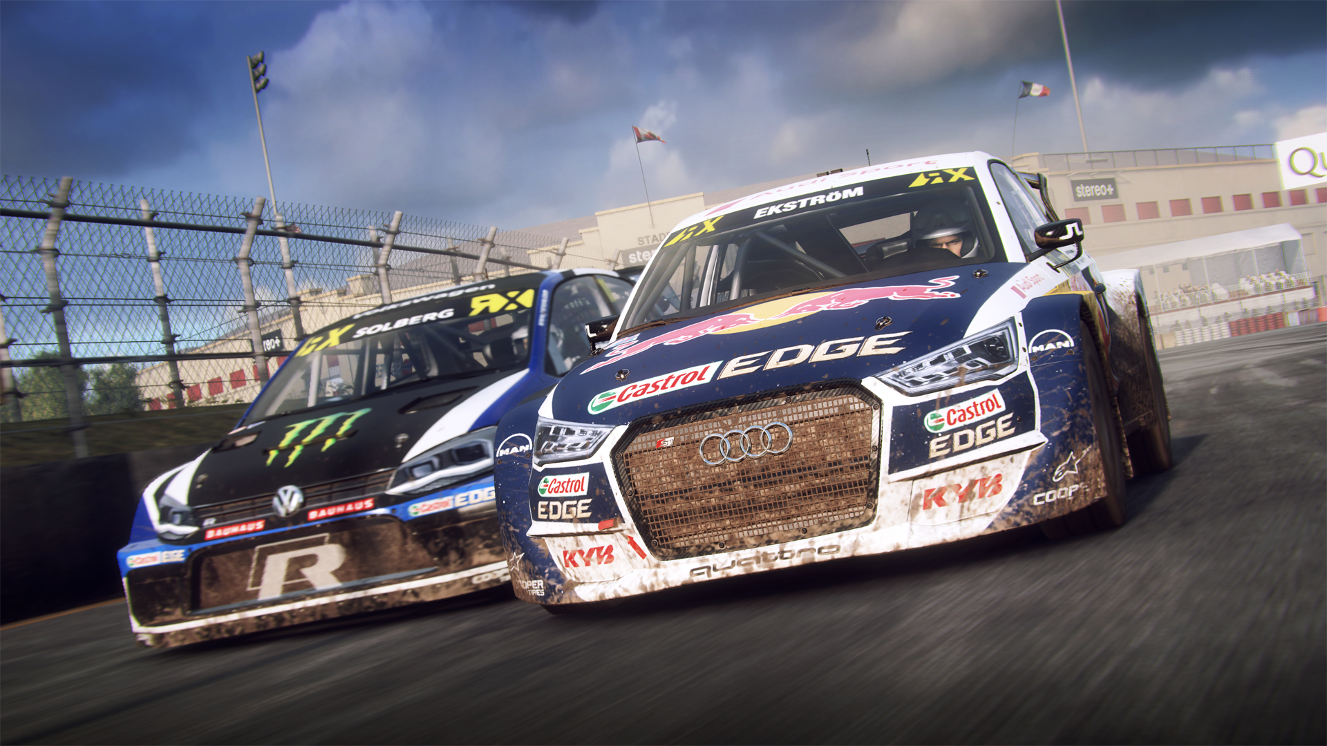 Zwei Rallyeautos rasen auf einer Schotterpiste, eines schwarz mit Monster-Logo, das andere blau.