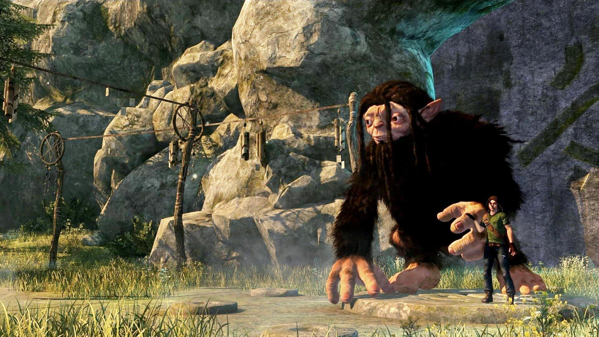 Ein großer Troll steht mit einem Jungen, mit einer Höhle und hängenden Objekten im Hintergrund.